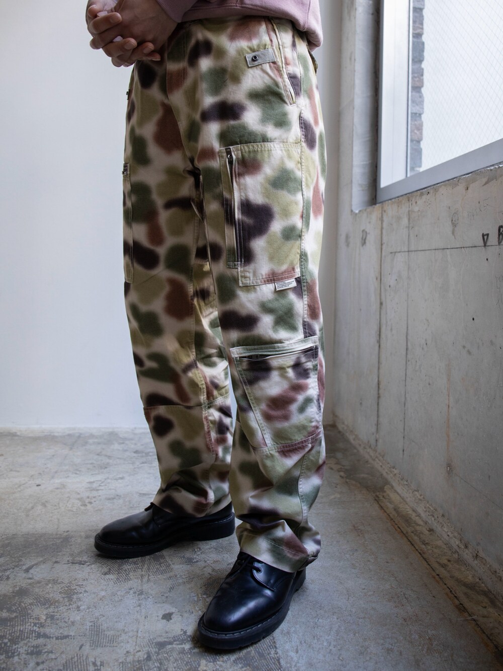 ピンク系のパーカー、その他のカーゴパンツ、グレー系のハットを着用したメンズの冬コーディネートの4枚目の写真