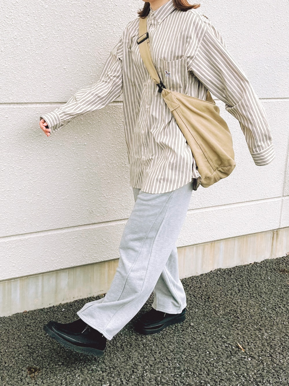 ベージュ系のシャツ/ブラウス、グレー系のスウェットパンツ、ベージュ系のショルダーバッグを着用したレディースの秋コーディネートの3枚目の写真