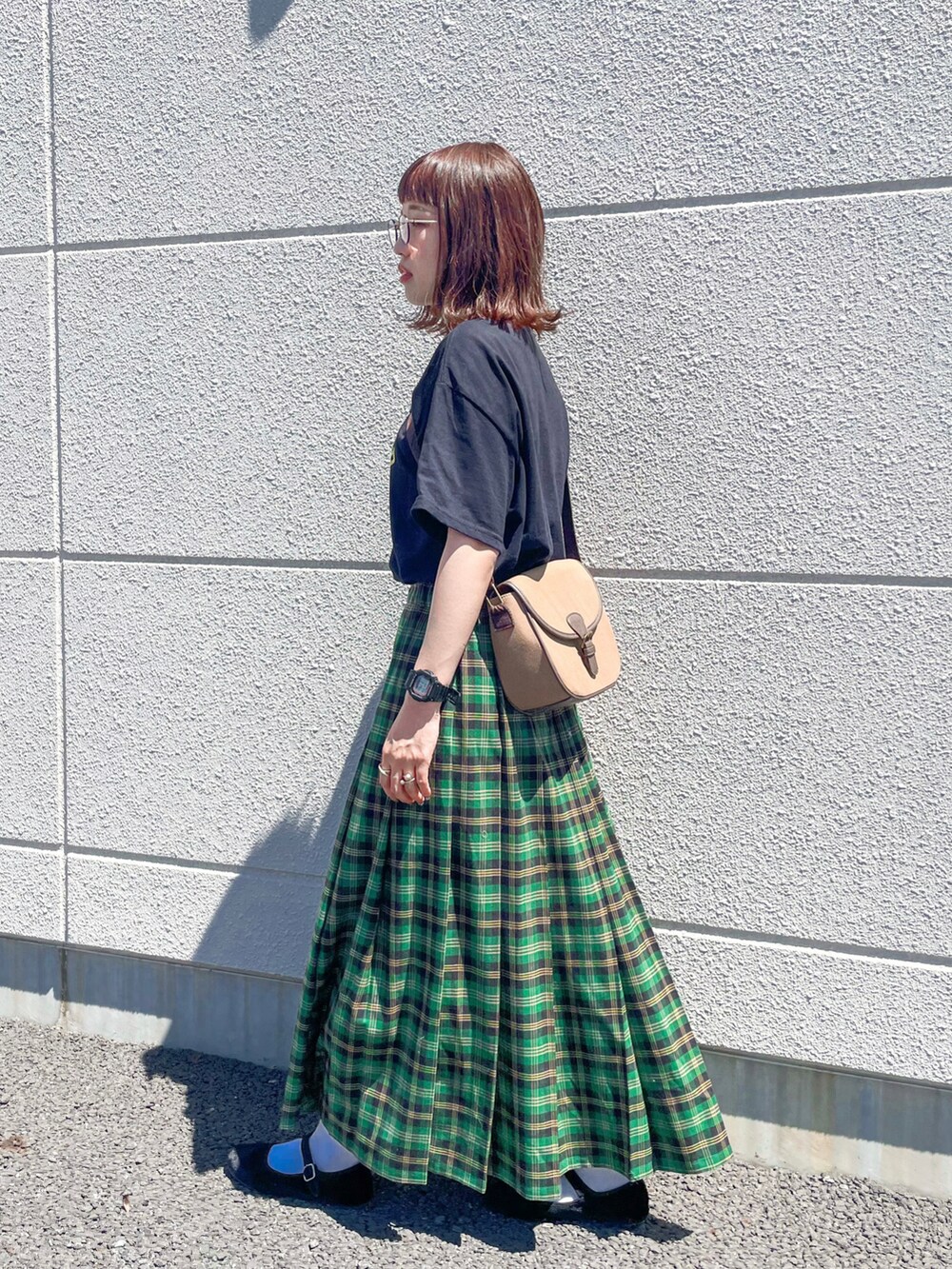 グリーン系のスカート、ブラック系のTシャツ/カットソー、ブラウン系のショルダーバッグを着用したレディースの夏コーディネートの4枚目の写真