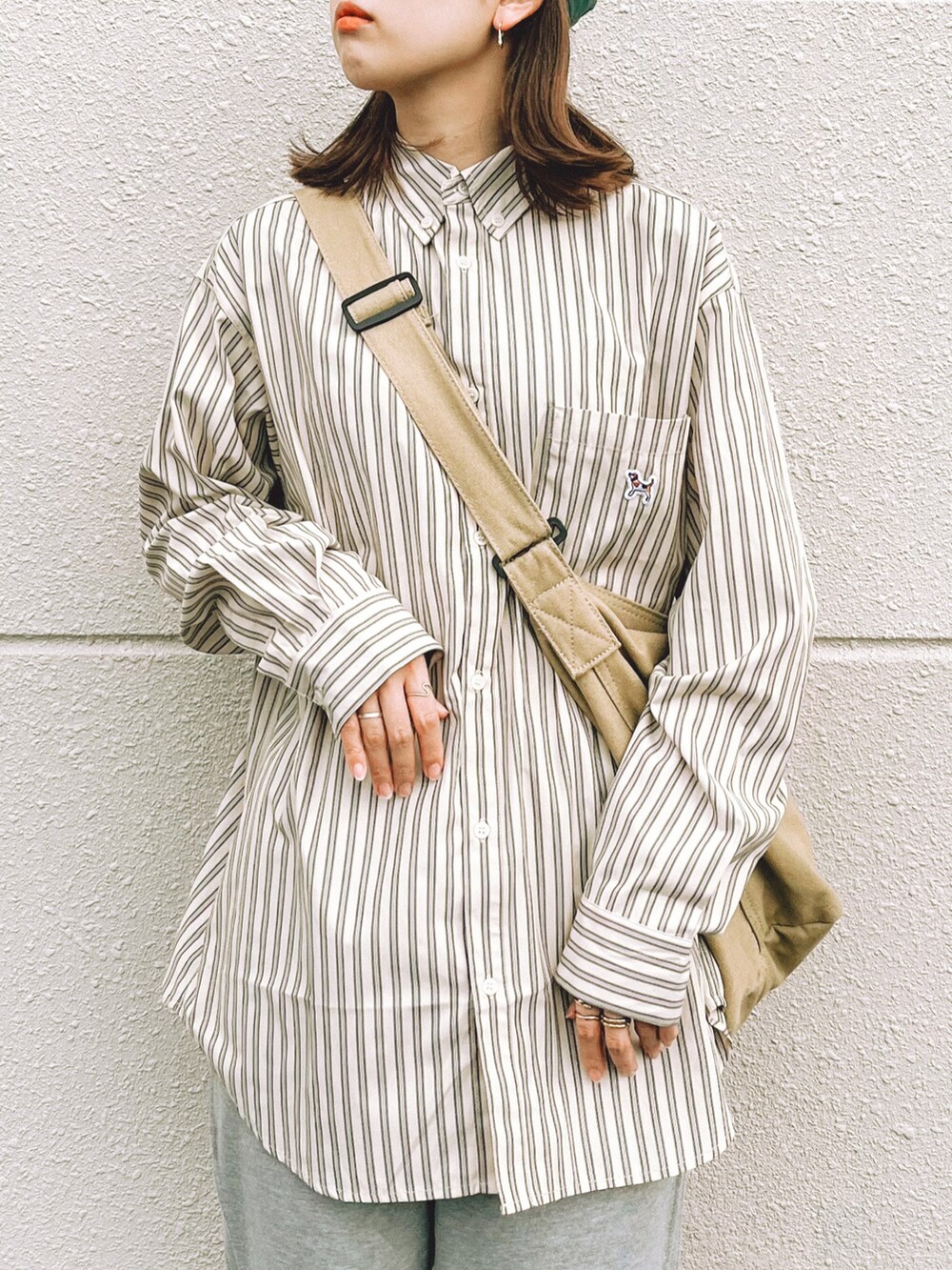 ベージュ系のシャツ/ブラウス、グレー系のスウェットパンツ、ベージュ系のショルダーバッグを着用したレディースの秋コーディネートの2枚目の写真