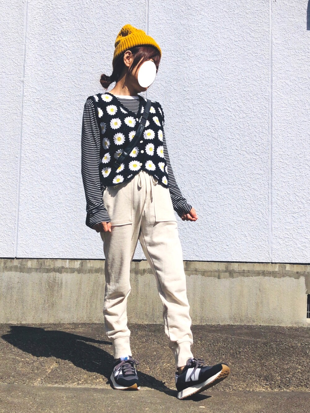 ブラック系のTシャツ/カットソー、ブラック系のベスト、ホワイト系のスウェットパンツを着用したレディースの秋コーディネートの3枚目の写真