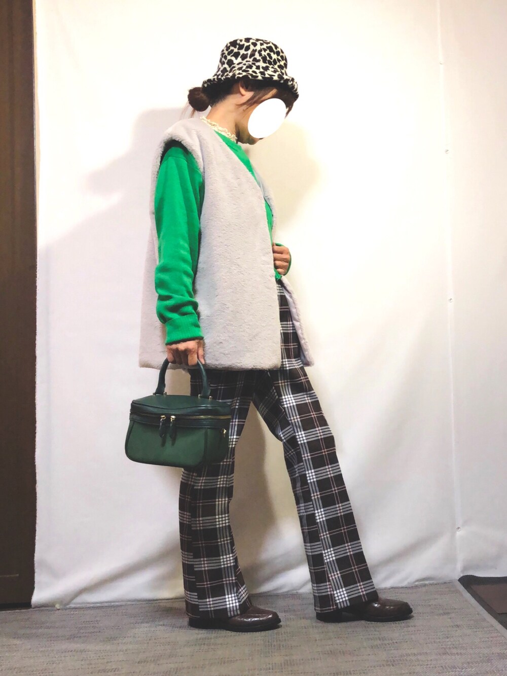 グレー系のベスト、グリーン系のカーディガン/ボレロ、ベージュ系のTシャツ/カットソーを着用したレディースの秋コーディネートの3枚目の写真