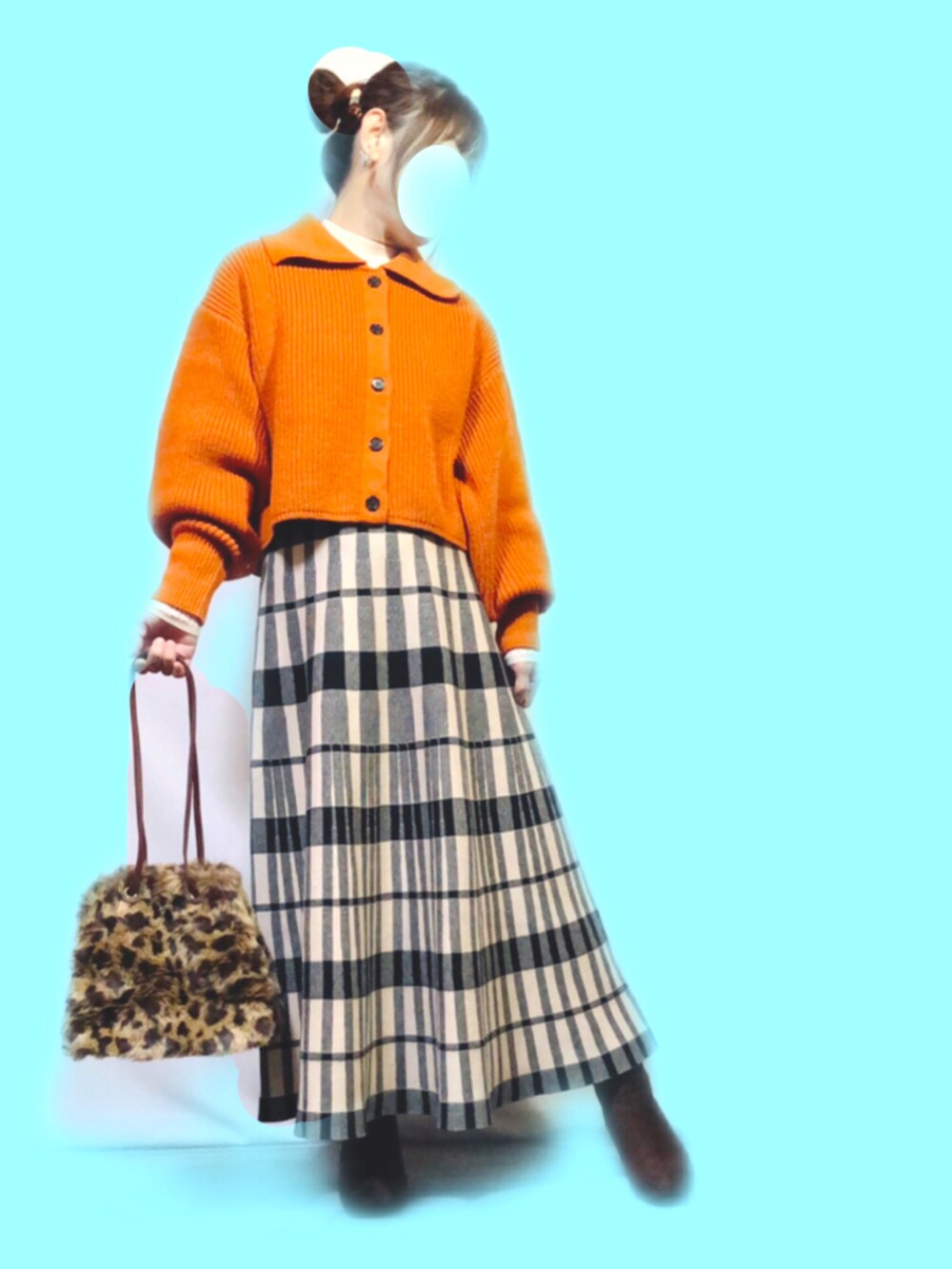 オレンジ系のニット/セーター、ホワイト系のニット/セーター、ブラック系のスカートを着用したレディースの冬コーディネートの2枚目の写真