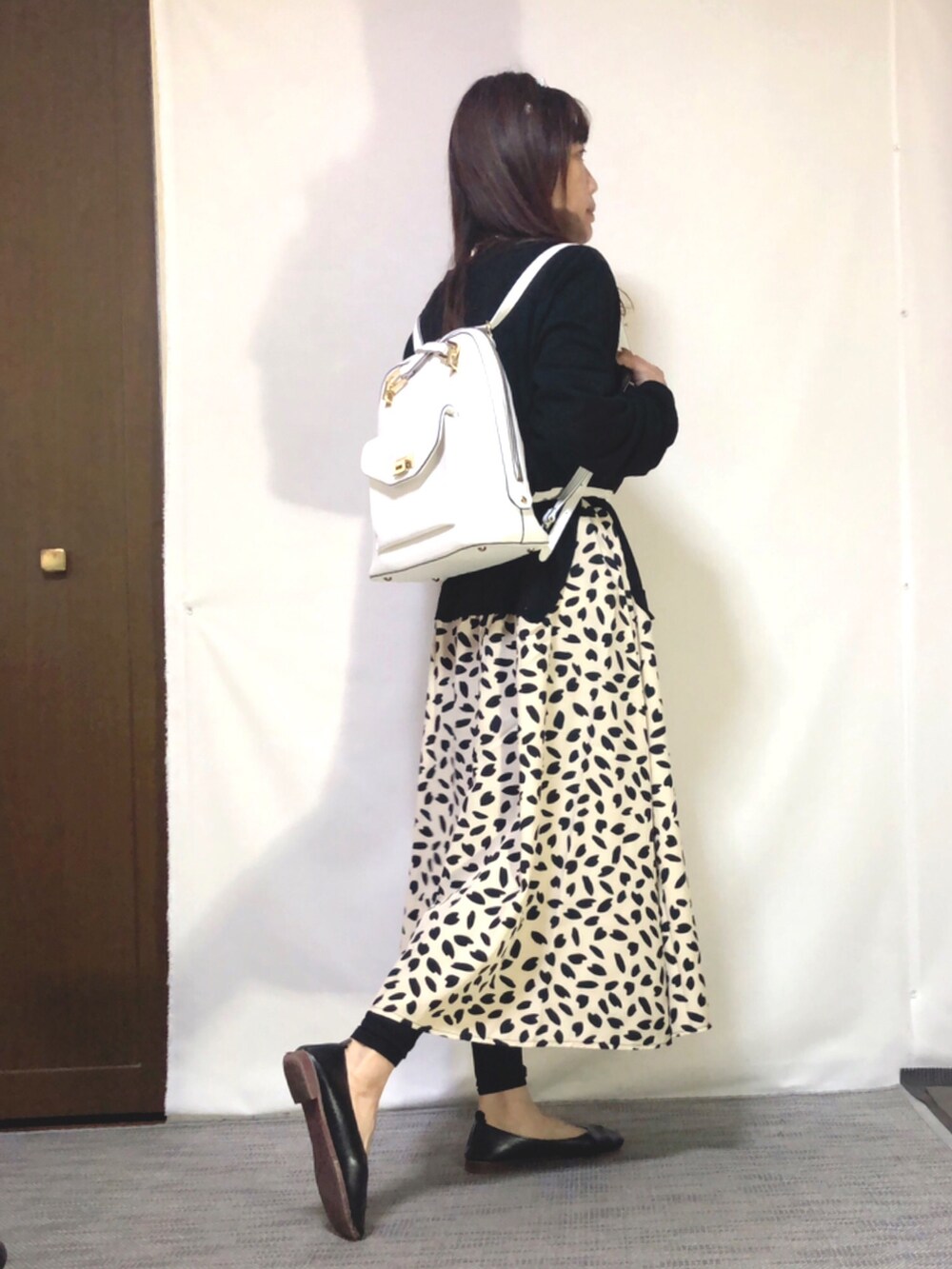 ベージュ系のワンピース、ブラック系のパンプス、ホワイト系のバッグを着用したレディースの春コーディネートの3枚目の写真