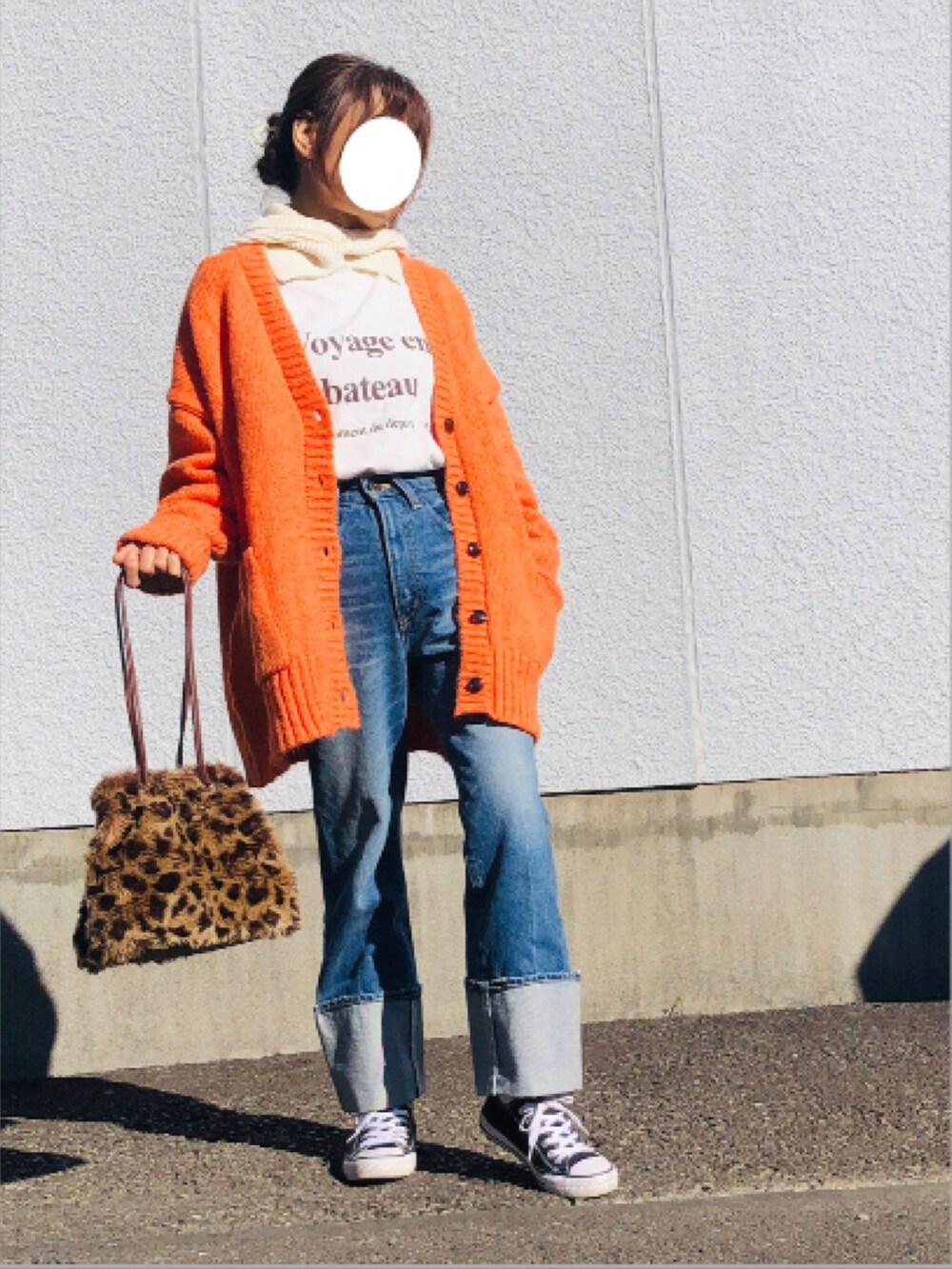 オレンジ系のカーディガン/ボレロ、ホワイト系のTシャツ/カットソー、ブルー系のデニムパンツを着用したレディースの冬コーディネートの3枚目の写真