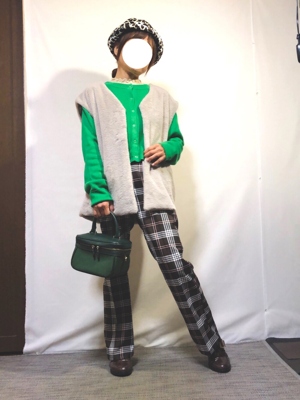 グレー系のベスト、グリーン系のカーディガン/ボレロ、ベージュ系のTシャツ/カットソーを着用したレディースの秋コーディネートの2枚目の写真