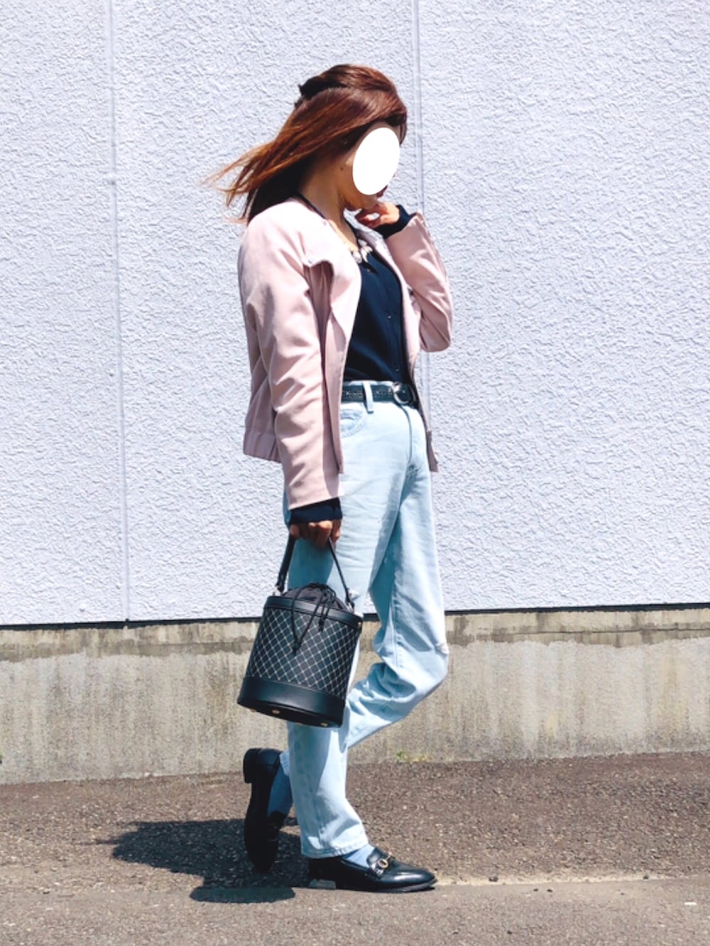 ピンク系のライダースジャケット、ブルー系のニット/セーター、ブルー系のデニムパンツを着用したレディースの春コーディネートの4枚目の写真