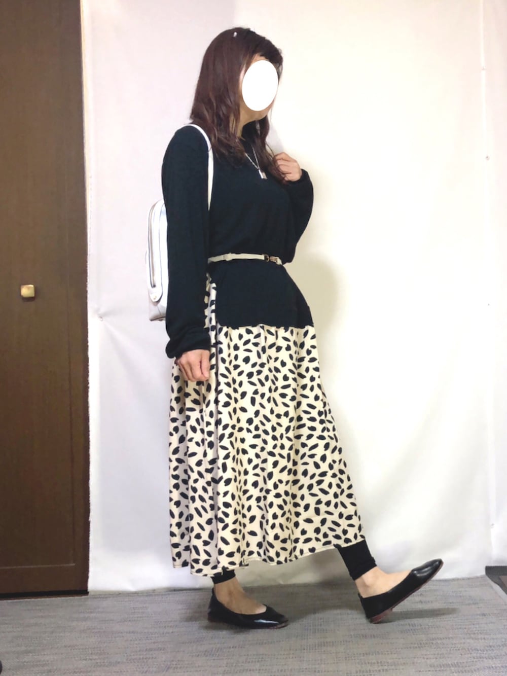 ベージュ系のワンピース、ブラック系のパンプス、ホワイト系のバッグを着用したレディースの春コーディネートの2枚目の写真
