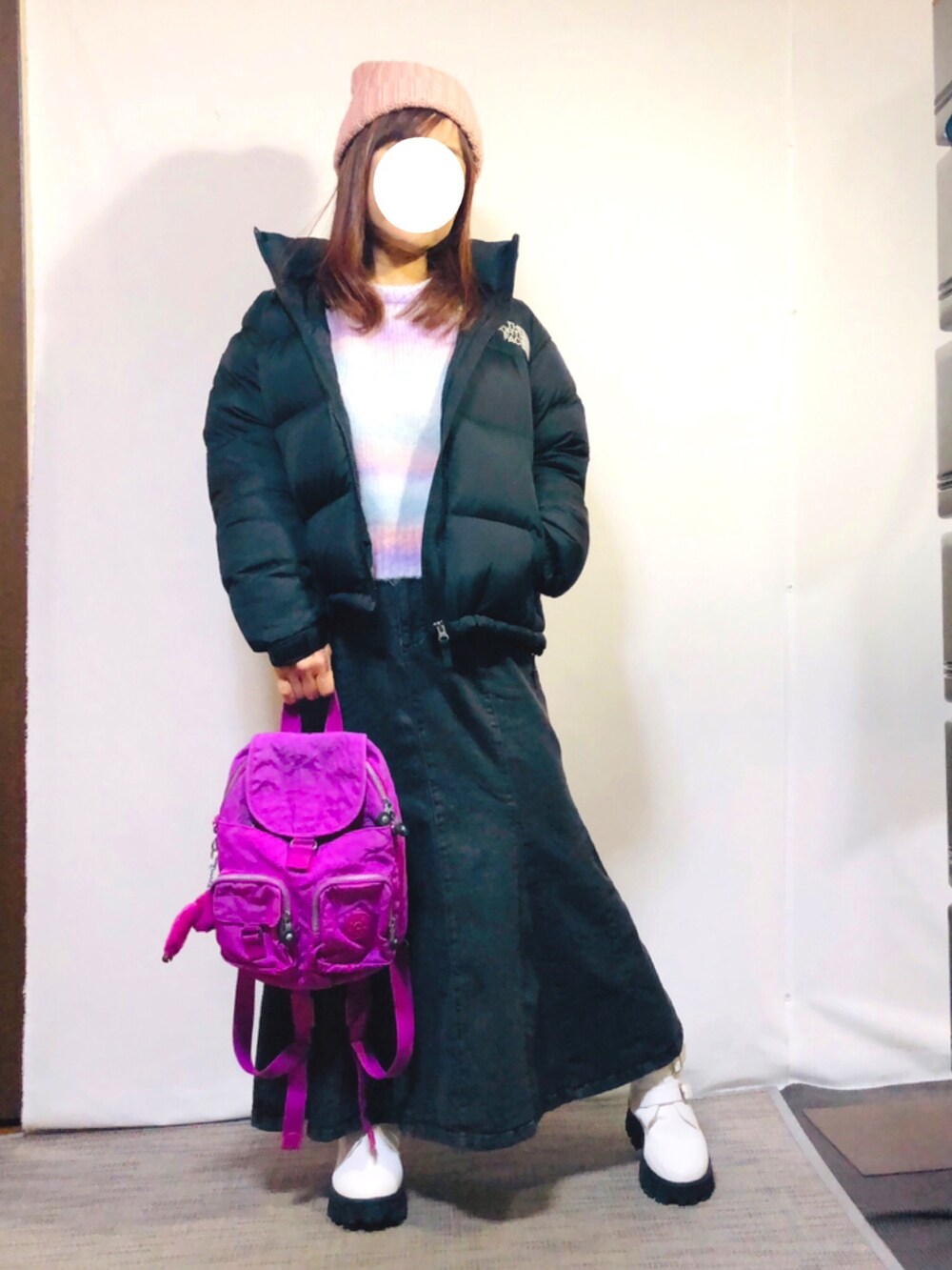 ブラック系のダウンジャケット/コート、パープル系のニット/セーター、グレー系のデニムスカートを着用したレディースの冬コーディネートの2枚目の写真