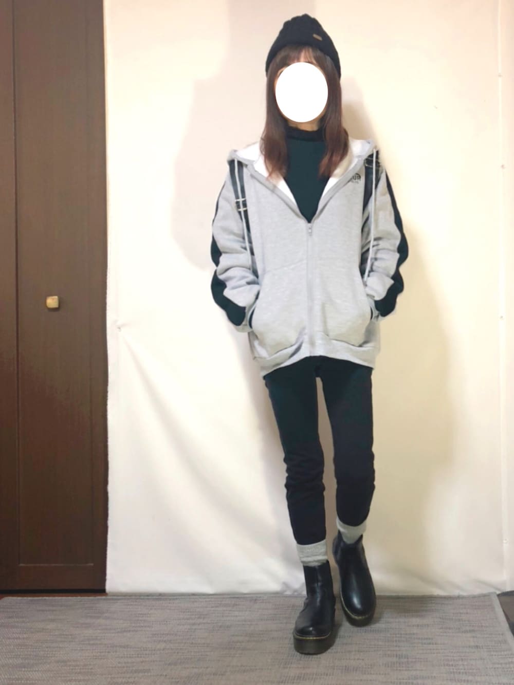 グレー系のパーカー、ブラック系のスウェット、ブラック系のパンツを着用したレディースの冬コーディネートの2枚目の写真