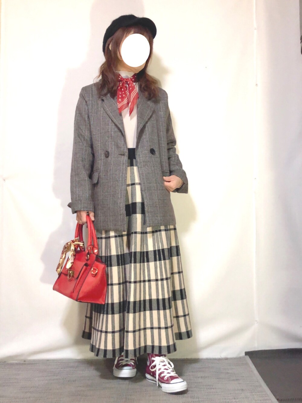 ブラウン系のテーラードジャケット、ベージュ系のニット/セーター、ブラック系のスカートを着用したレディースの春コーディネートの2枚目の写真