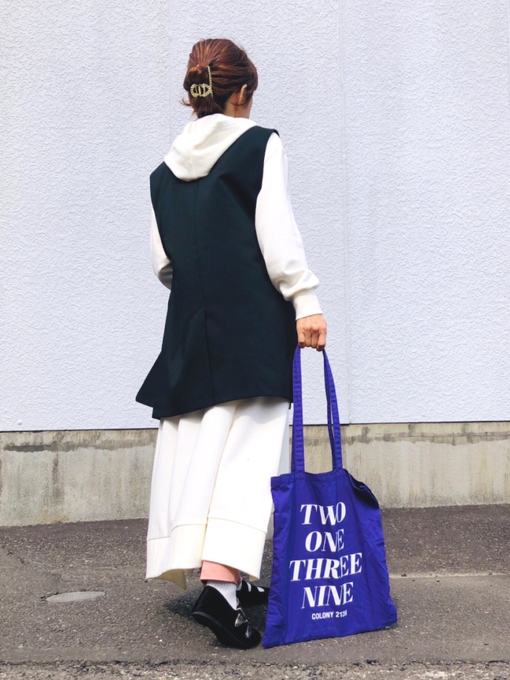 ホワイト系のワンピース、ピンク系のタンクトップ、ブラック系のベストを着用したレディースの春コーディネートの3枚目の写真