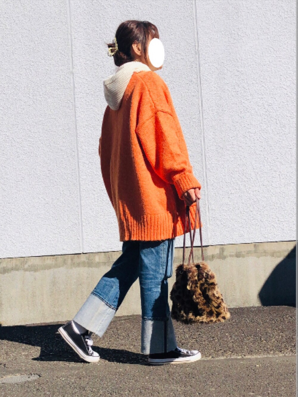 オレンジ系のカーディガン/ボレロ、ホワイト系のTシャツ/カットソー、ブルー系のデニムパンツを着用したレディースの冬コーディネートの4枚目の写真