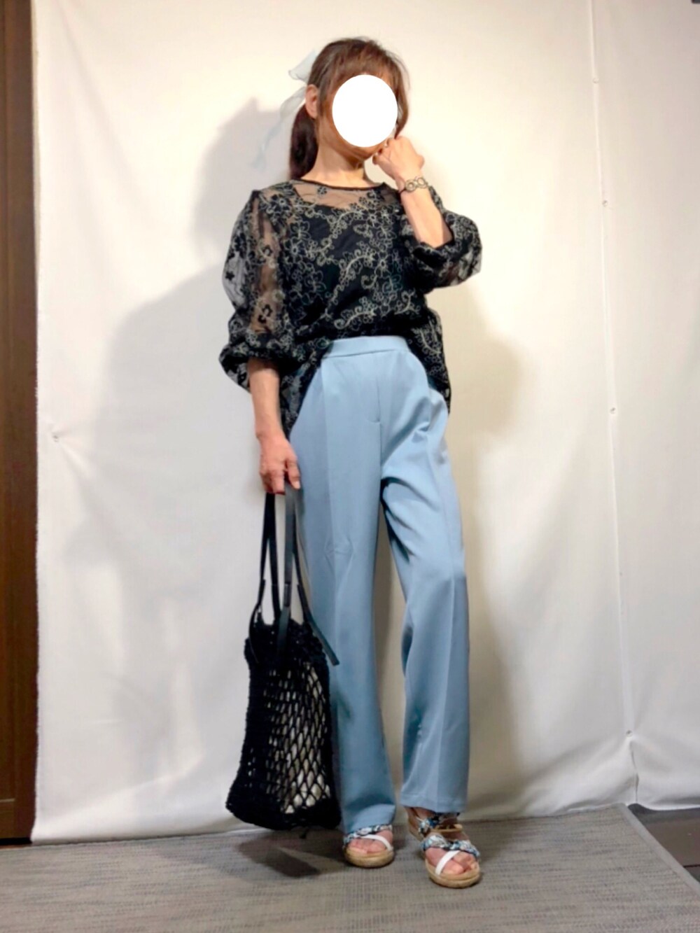 ブラック系のシャツ/ブラウス、ブルー系のスラックス、ホワイト系のサンダルを着用したレディースの夏コーディネートの2枚目の写真