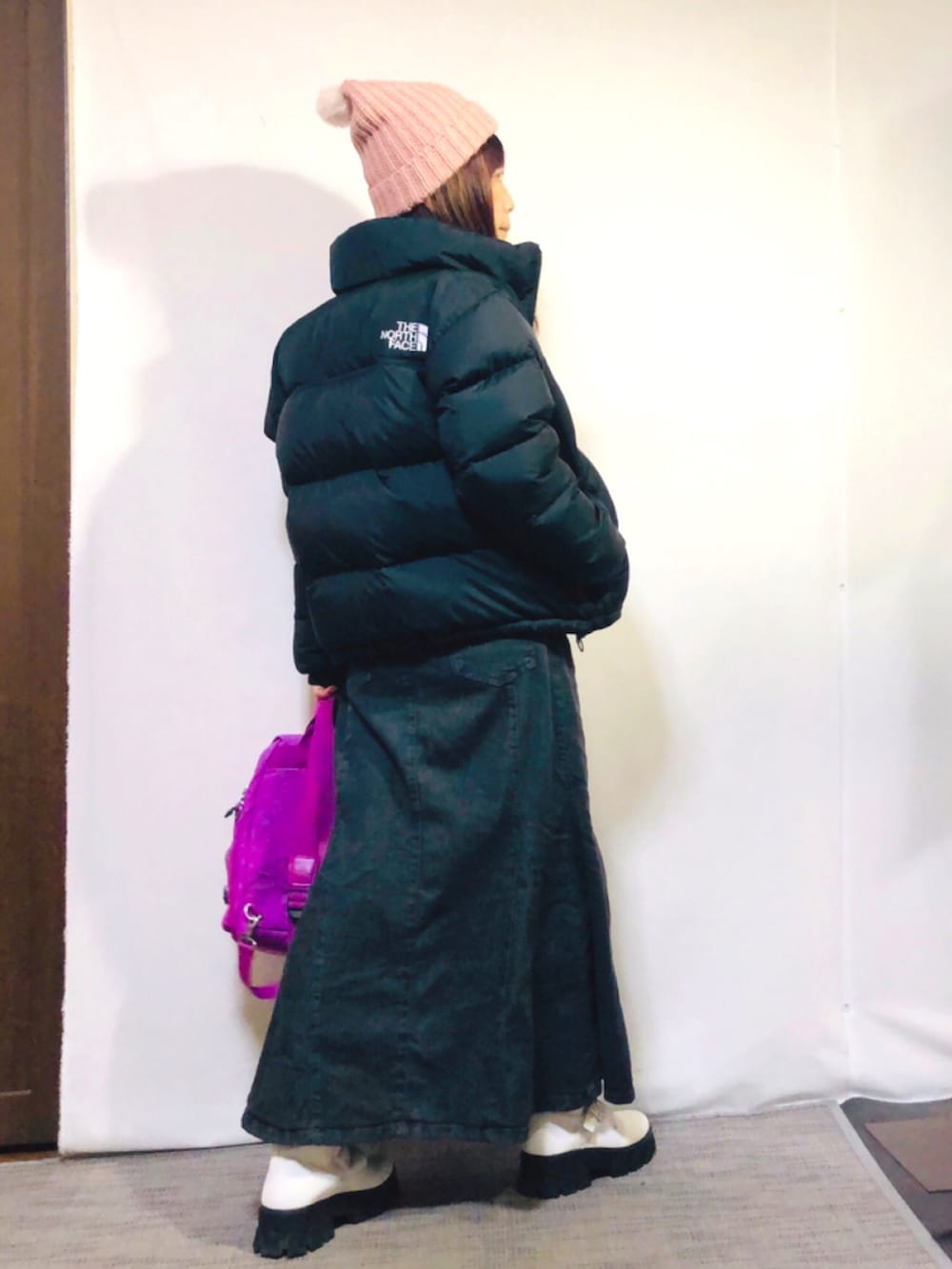 ブラック系のダウンジャケット/コート、パープル系のニット/セーター、グレー系のデニムスカートを着用したレディースの冬コーディネートの3枚目の写真