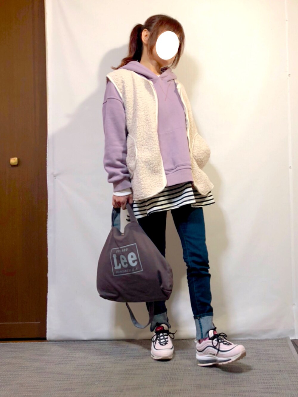 ホワイト系のベスト、パープル系のパーカー、ブラック系のTシャツ/カットソーを着用したレディースの冬コーディネートの2枚目の写真