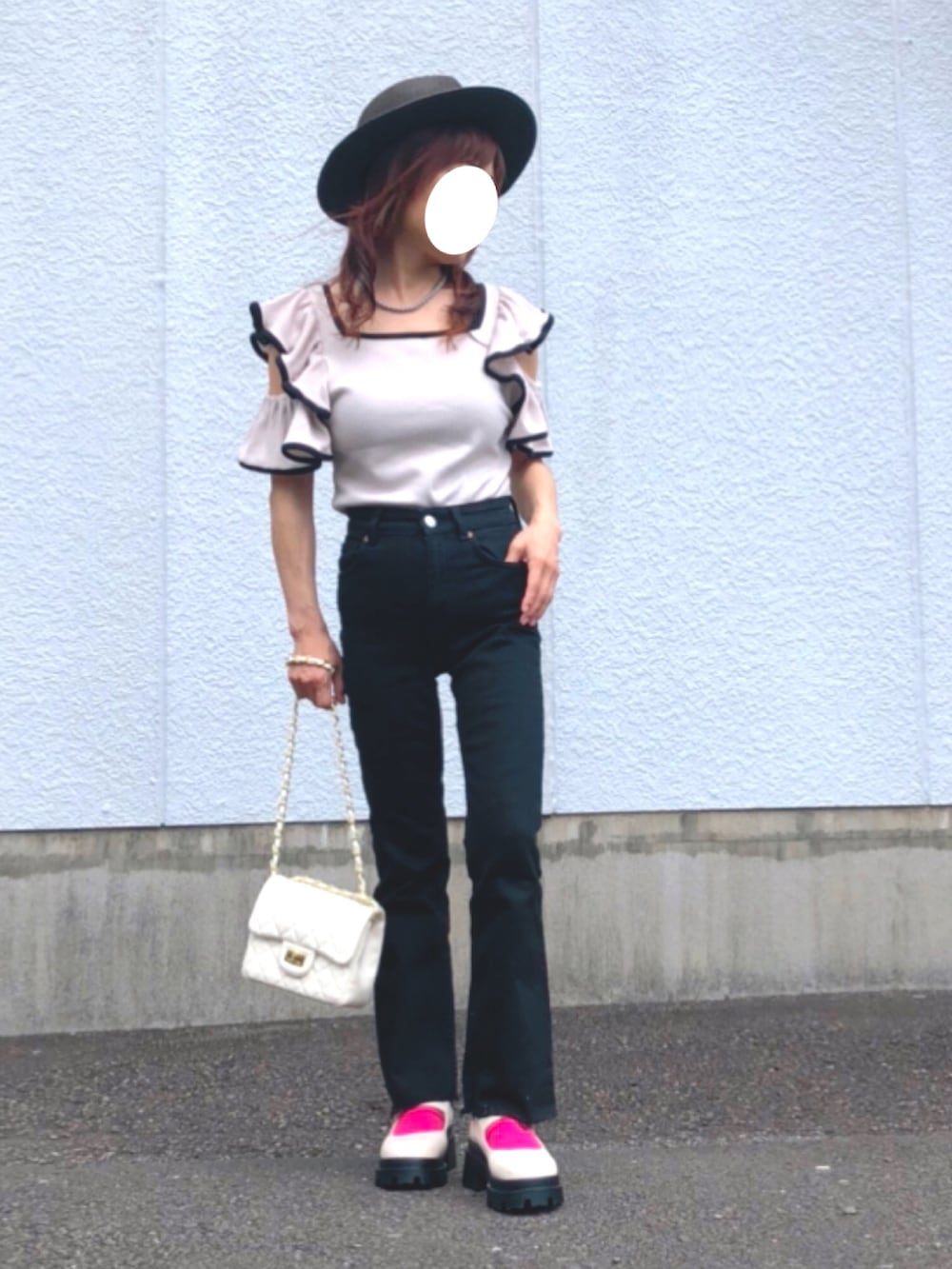 ベージュ系のニット/セーター、ブラック系のデニムパンツ、ホワイト系のドレスシューズを着用したレディースの夏コーディネートの2枚目の写真