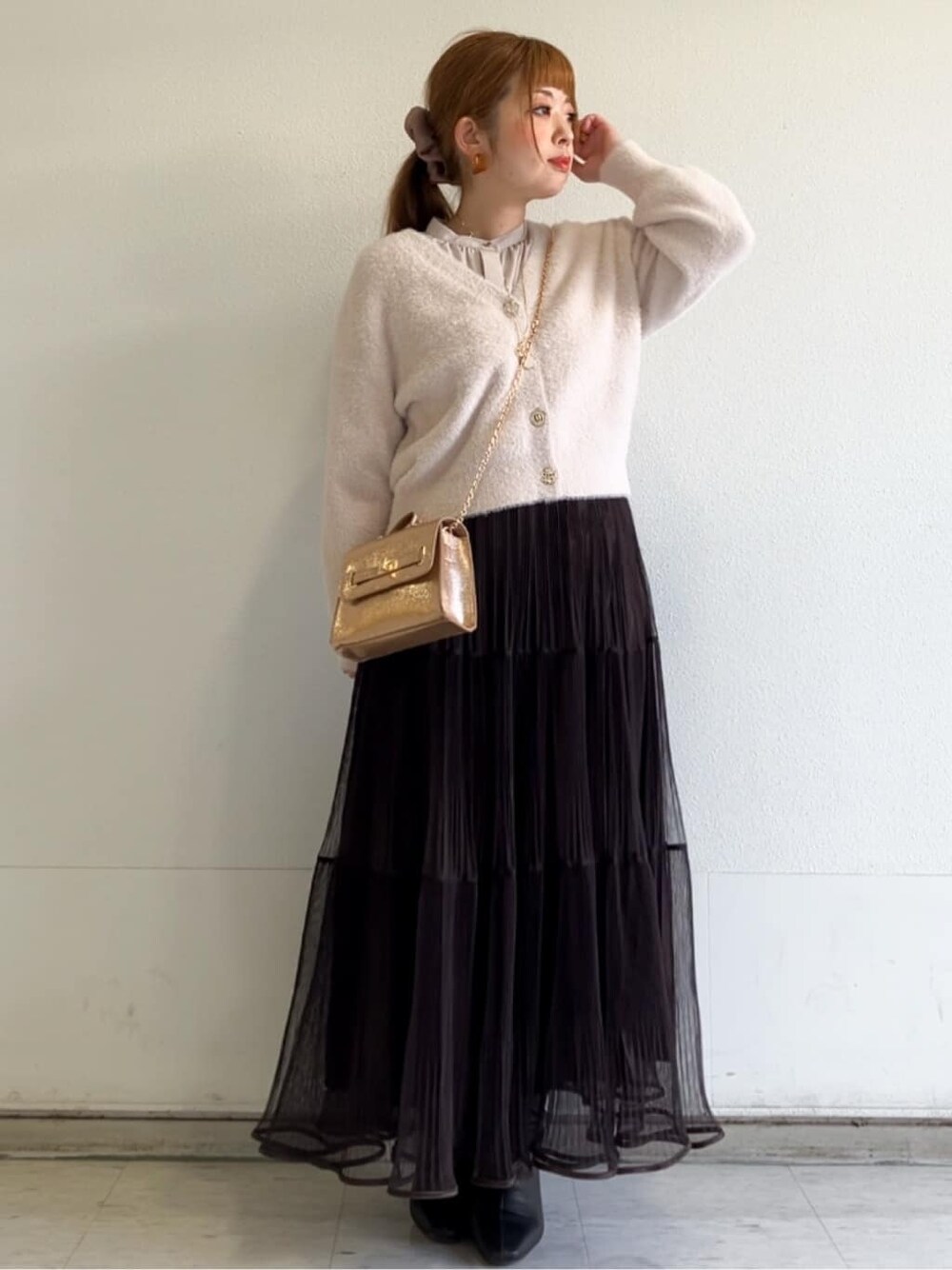 ピンク系のカーディガン/ボレロ、ベージュ系のシャツ/ブラウス、ブラウン系のスカートを着用したレディースの秋コーディネートの5枚目の写真