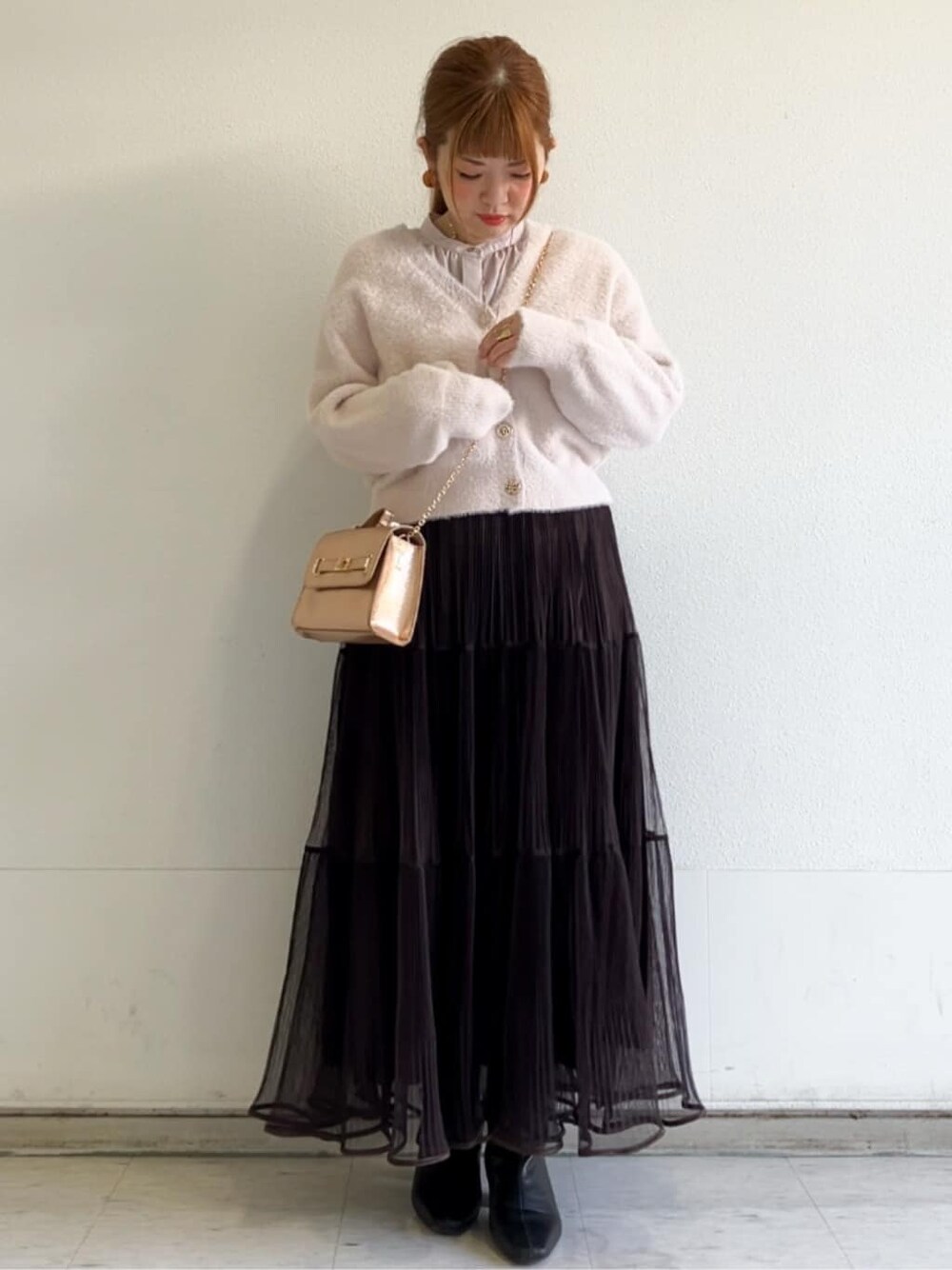 ピンク系のカーディガン/ボレロ、ベージュ系のシャツ/ブラウス、ブラウン系のスカートを着用したレディースの秋コーディネートの4枚目の写真