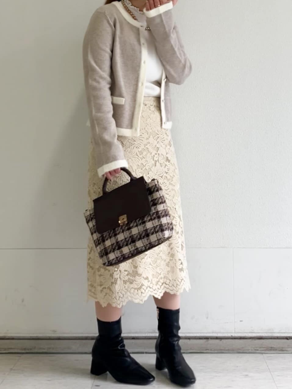 ベージュ系のカーディガン/ボレロ、ホワイト系のニット/セーター、イエロー系のスカートを着用したレディースの冬コーディネートの10枚目の写真