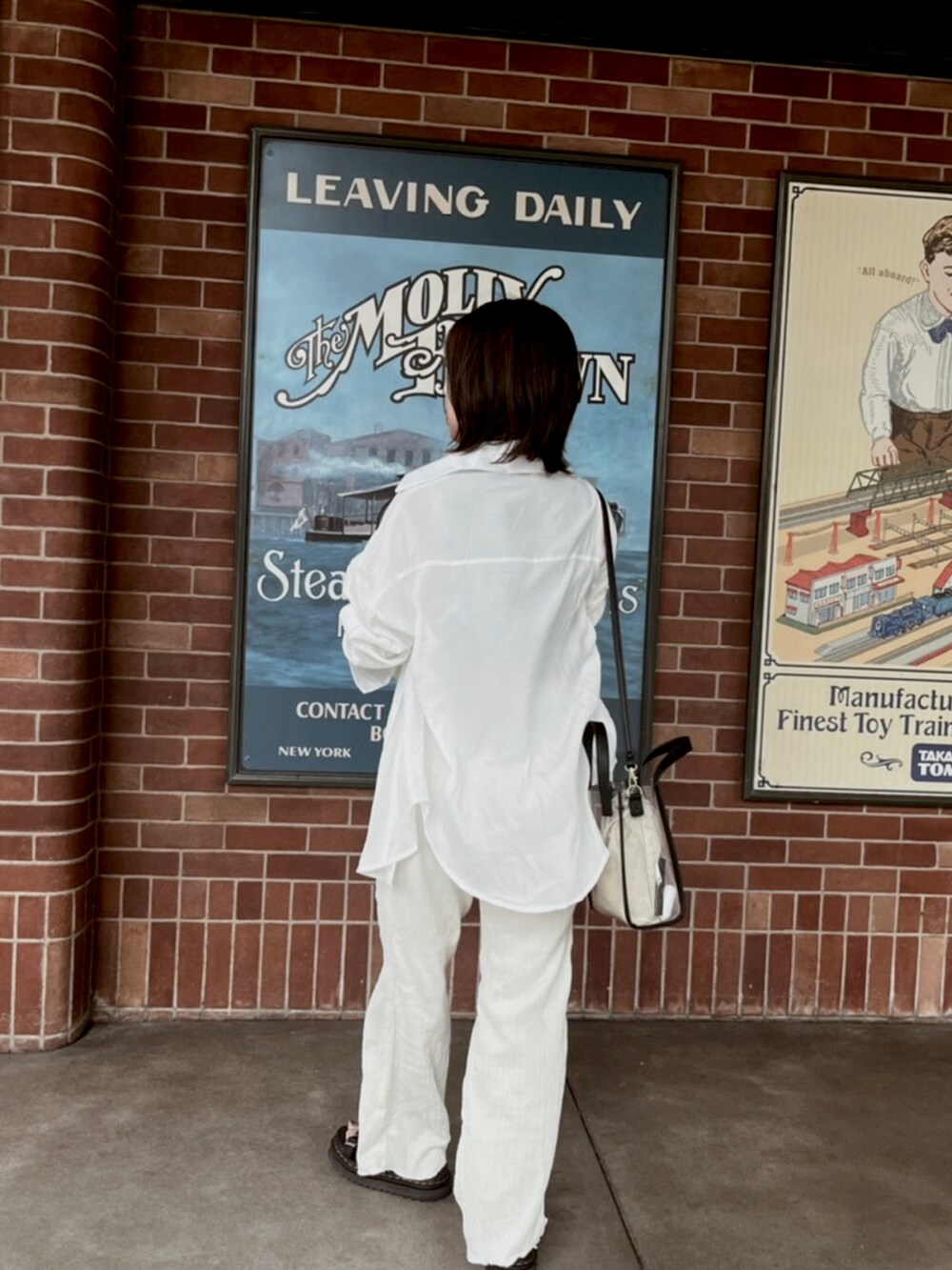 ホワイト系のシャツ/ブラウス、ホワイト系のスラックス、ブラック系のサンダルを着用したレディースの冬コーディネートの2枚目の写真