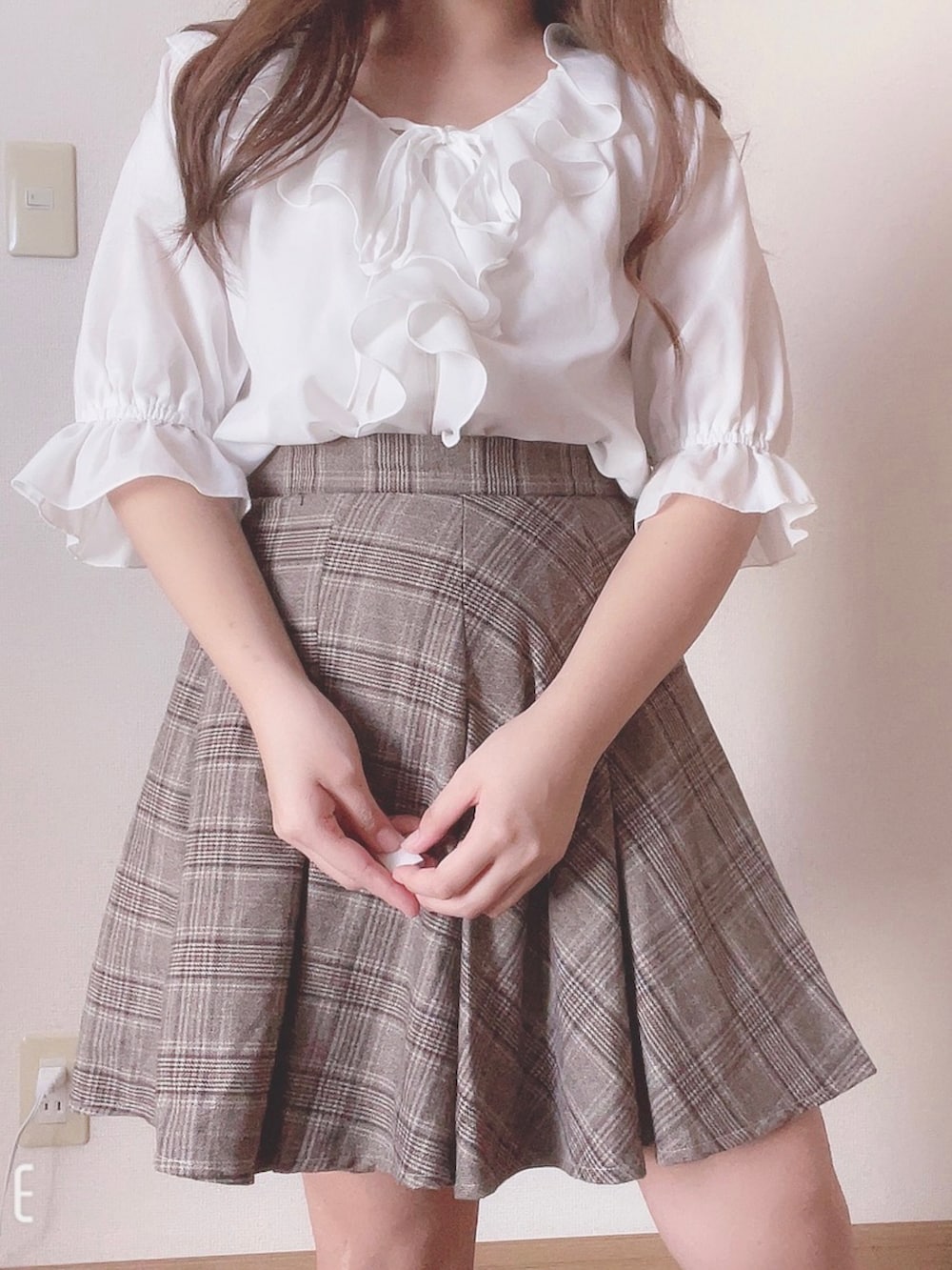 ブラウン系のスカート、ホワイト系のトップスを着用したレディースの夏コーディネートの2枚目の写真