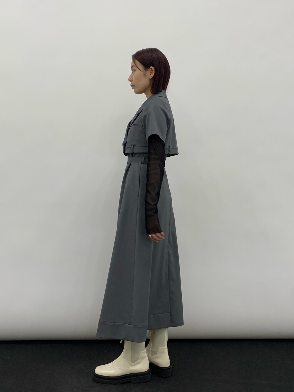 グレー系のワンピース、ブラック系のTシャツ/カットソー、ホワイト系のシューズを着用したレディースの秋コーディネートの2枚目の写真