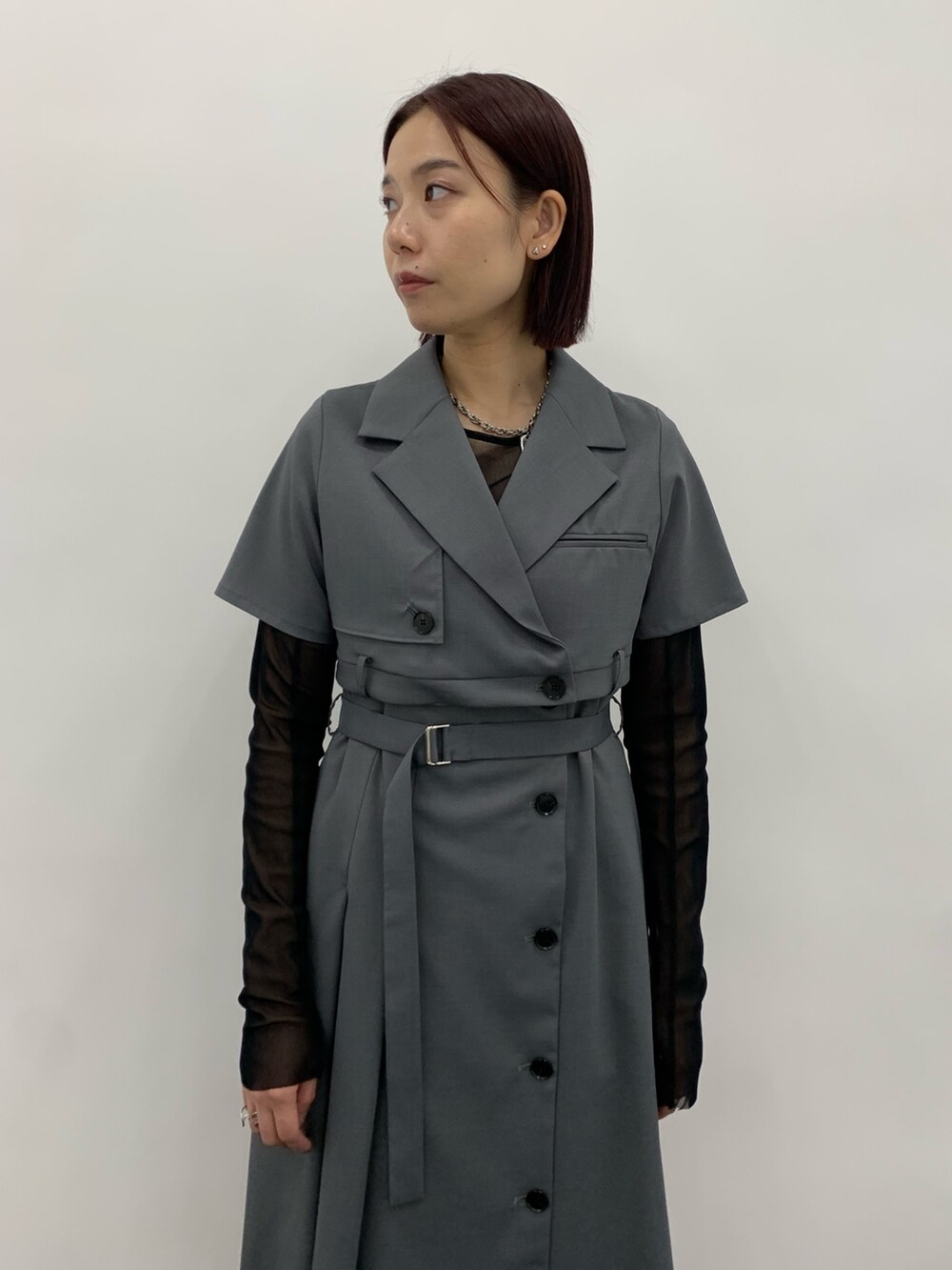 グレー系のワンピース、ブラック系のTシャツ/カットソー、ホワイト系のシューズを着用したレディースの秋コーディネートの4枚目の写真