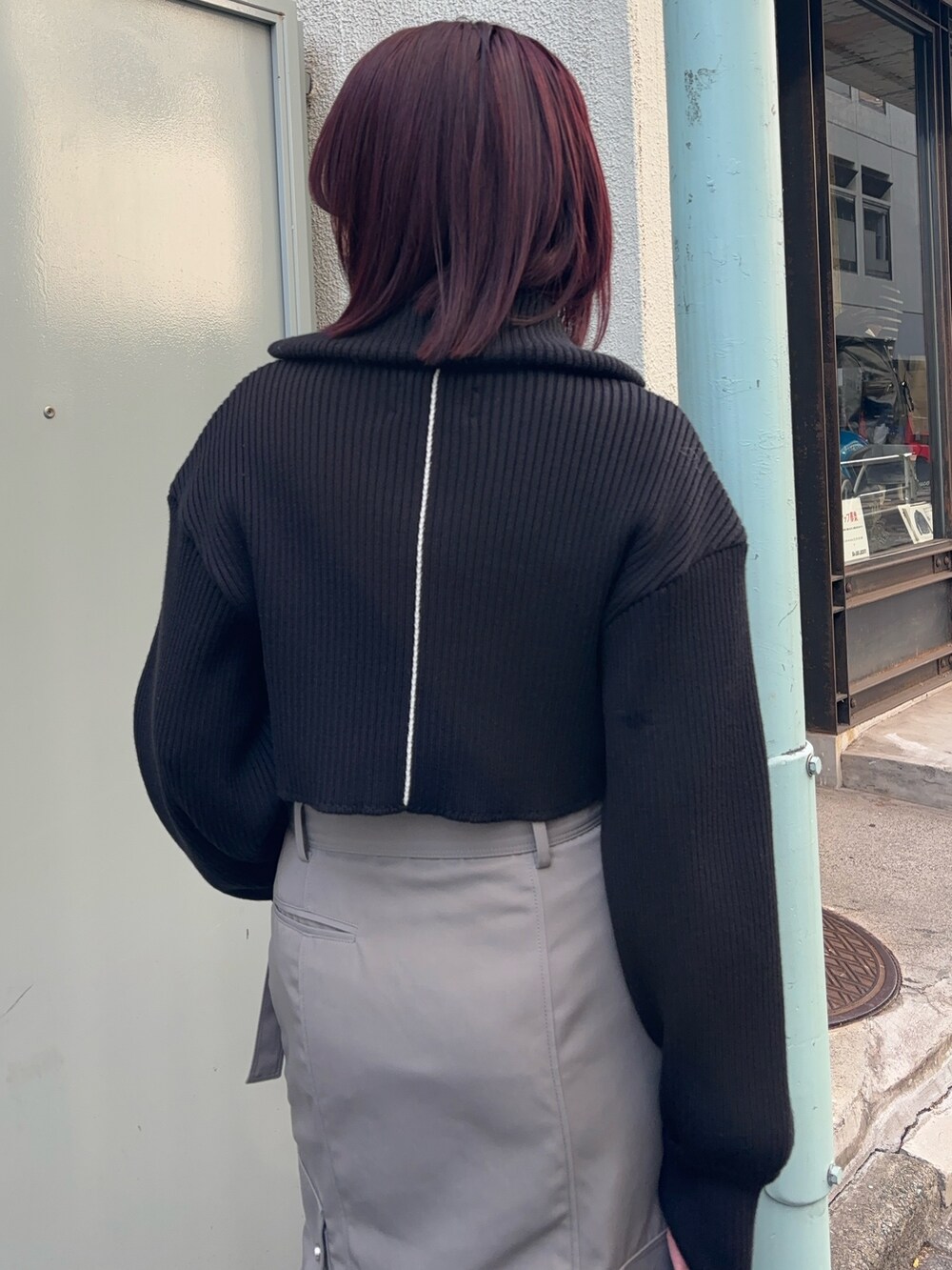 ブラック系のニット/セーター、ブラウン系のTシャツ/カットソー、グレー系のスカートを着用したレディースの冬コーディネートの5枚目の写真