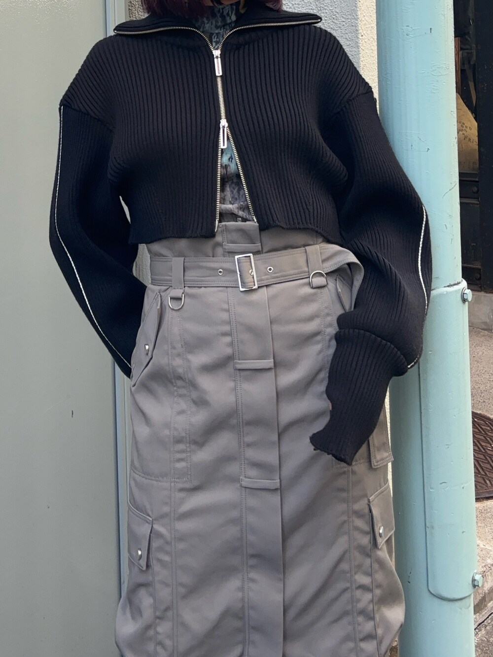 ブラック系のニット/セーター、ブラウン系のTシャツ/カットソー、グレー系のスカートを着用したレディースの冬コーディネートの4枚目の写真