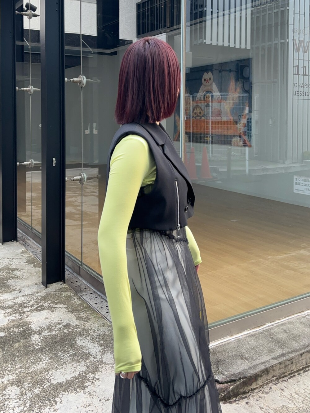 ブラック系のワンピース、グリーン系のTシャツ/カットソー、ホワイト系のスカートを着用したレディースの秋コーディネートの5枚目の写真