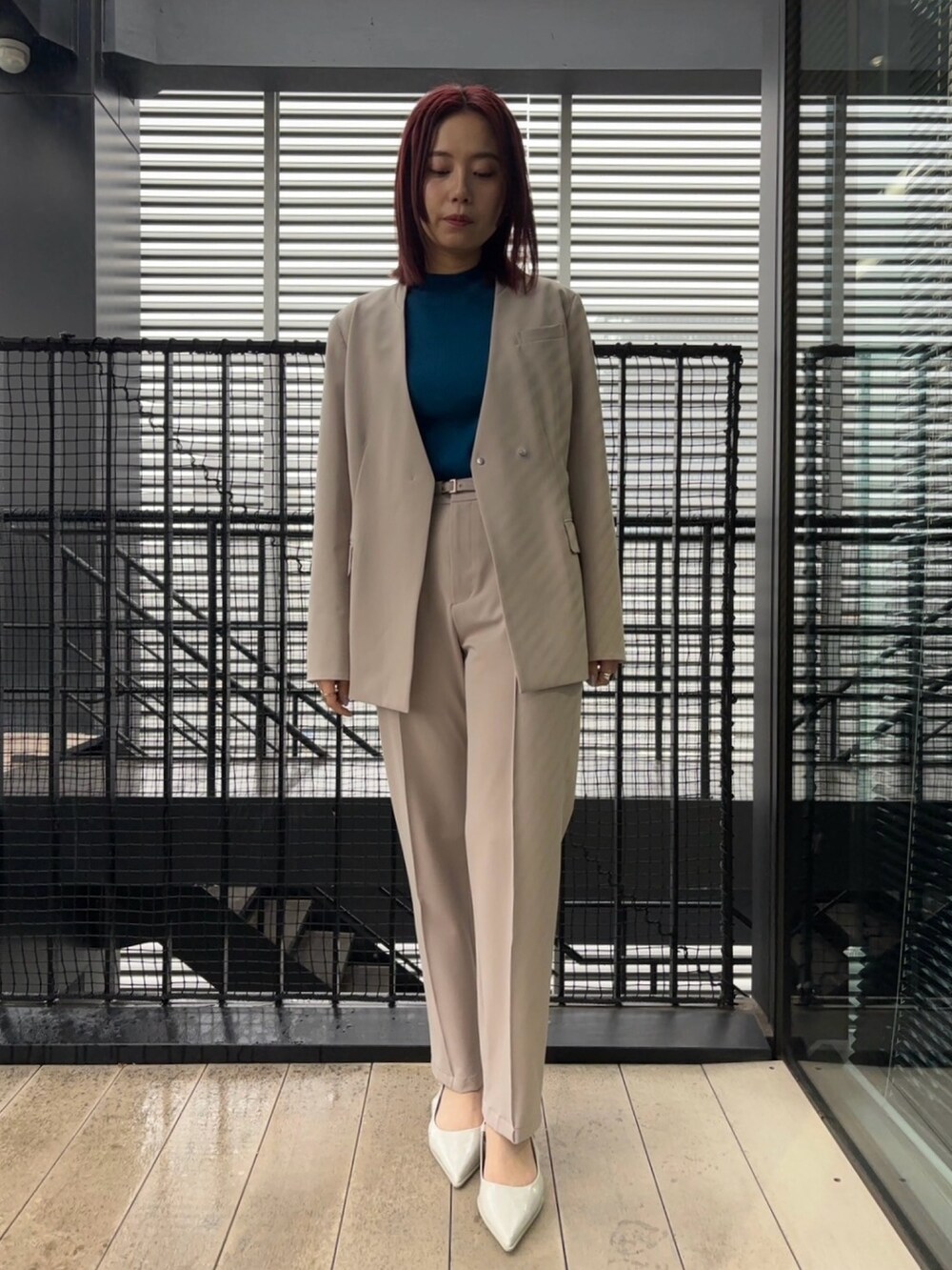 ブルー系のニット/セーター、ベージュ系のスラックス、ベージュ系のセットアップを着用したレディースの冬コーディネートの4枚目の写真