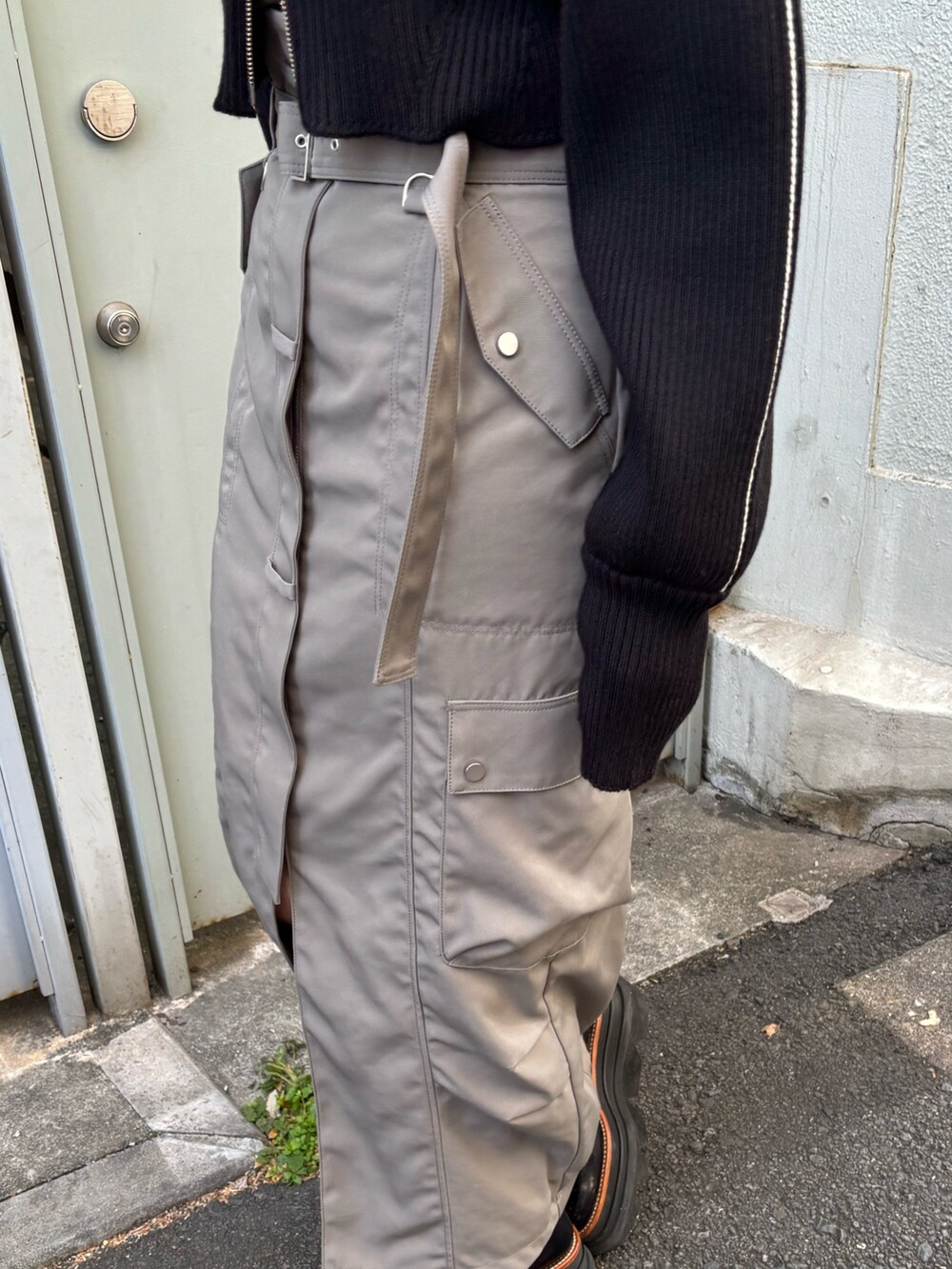 ブラック系のニット/セーター、ブラウン系のTシャツ/カットソー、グレー系のスカートを着用したレディースの冬コーディネートの7枚目の写真