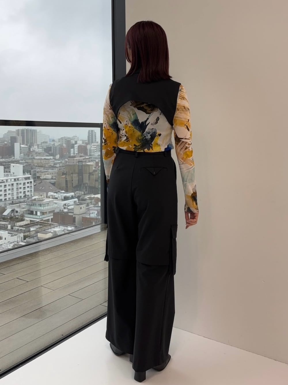 ブラック系のジャンパースカート、ブラック系のカーゴパンツ、イエロー系のTシャツ/カットソーを着用したレディースの冬コーディネートの3枚目の写真