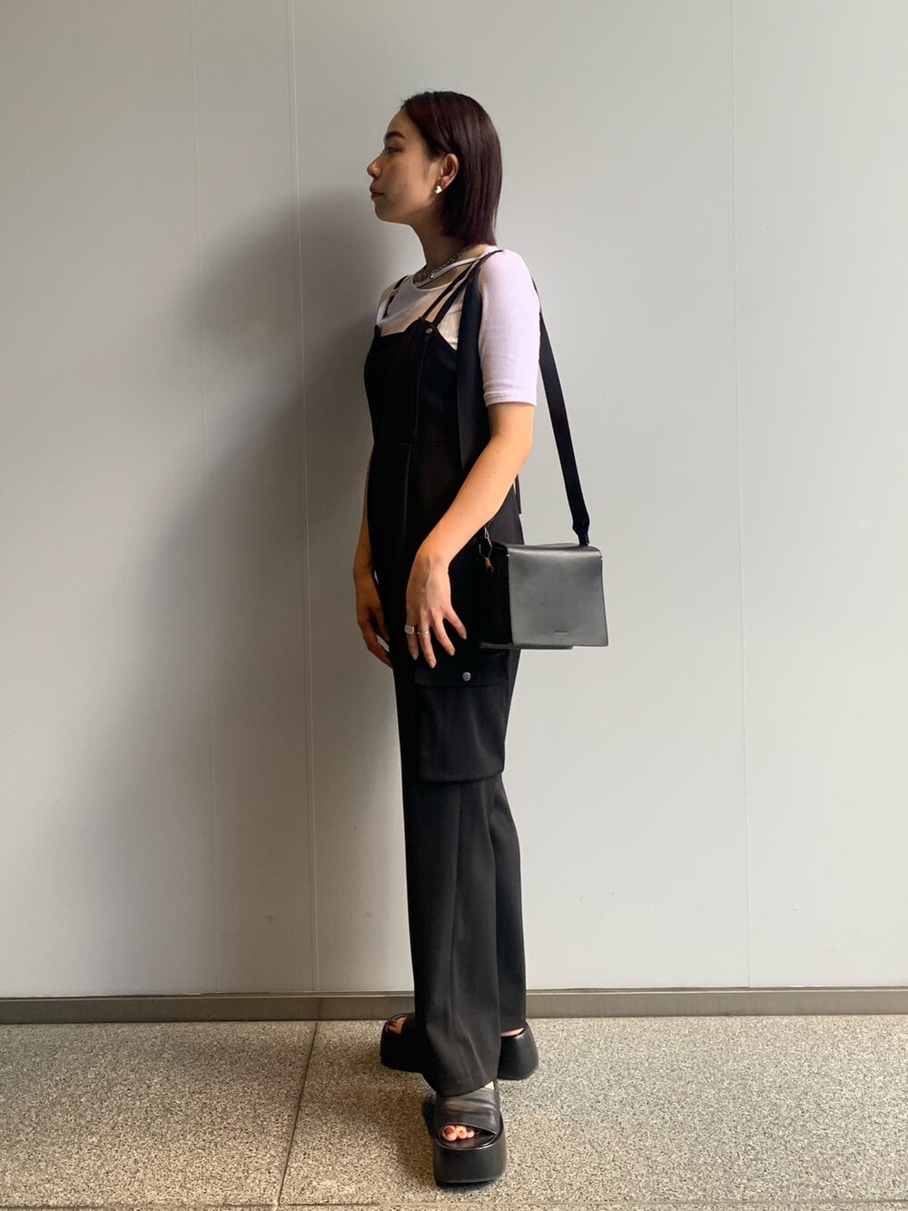 ホワイト系のTシャツ/カットソー、ブラック系のつなぎ/オールインワンを着用したレディースの夏コーディネートの3枚目の写真