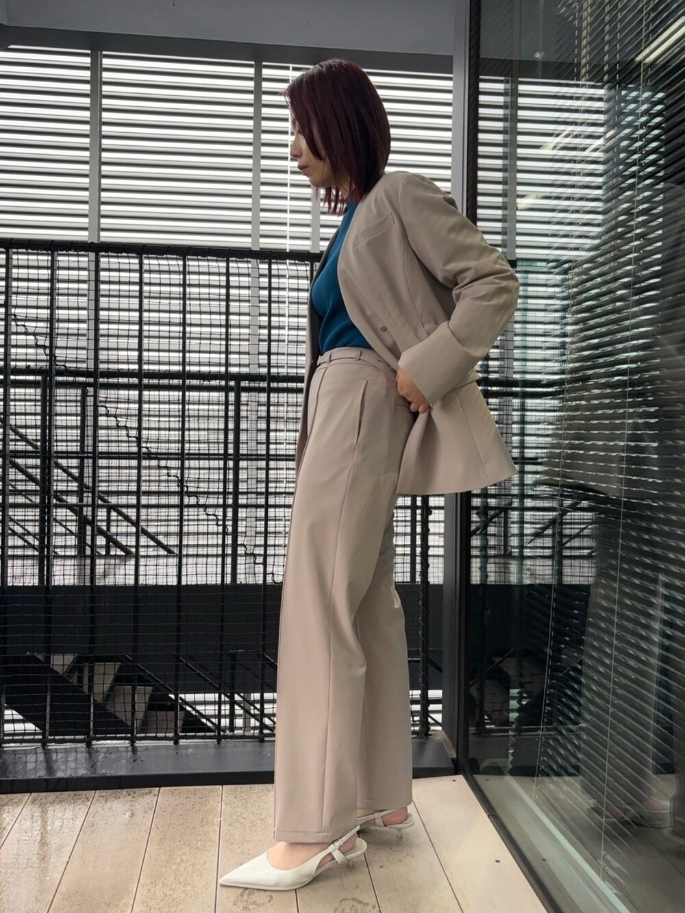 ブルー系のニット/セーター、ベージュ系のスラックス、ベージュ系のセットアップを着用したレディースの冬コーディネートの5枚目の写真