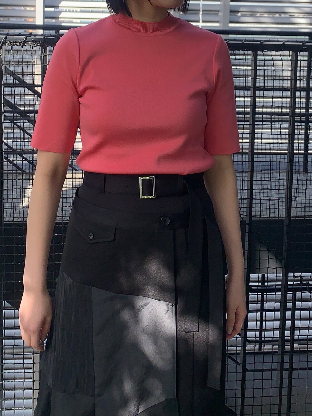 ピンク系のニット/セーター、ブラック系のスカート、ブラック系のその他シューズを着用したレディースの春コーディネートの4枚目の写真