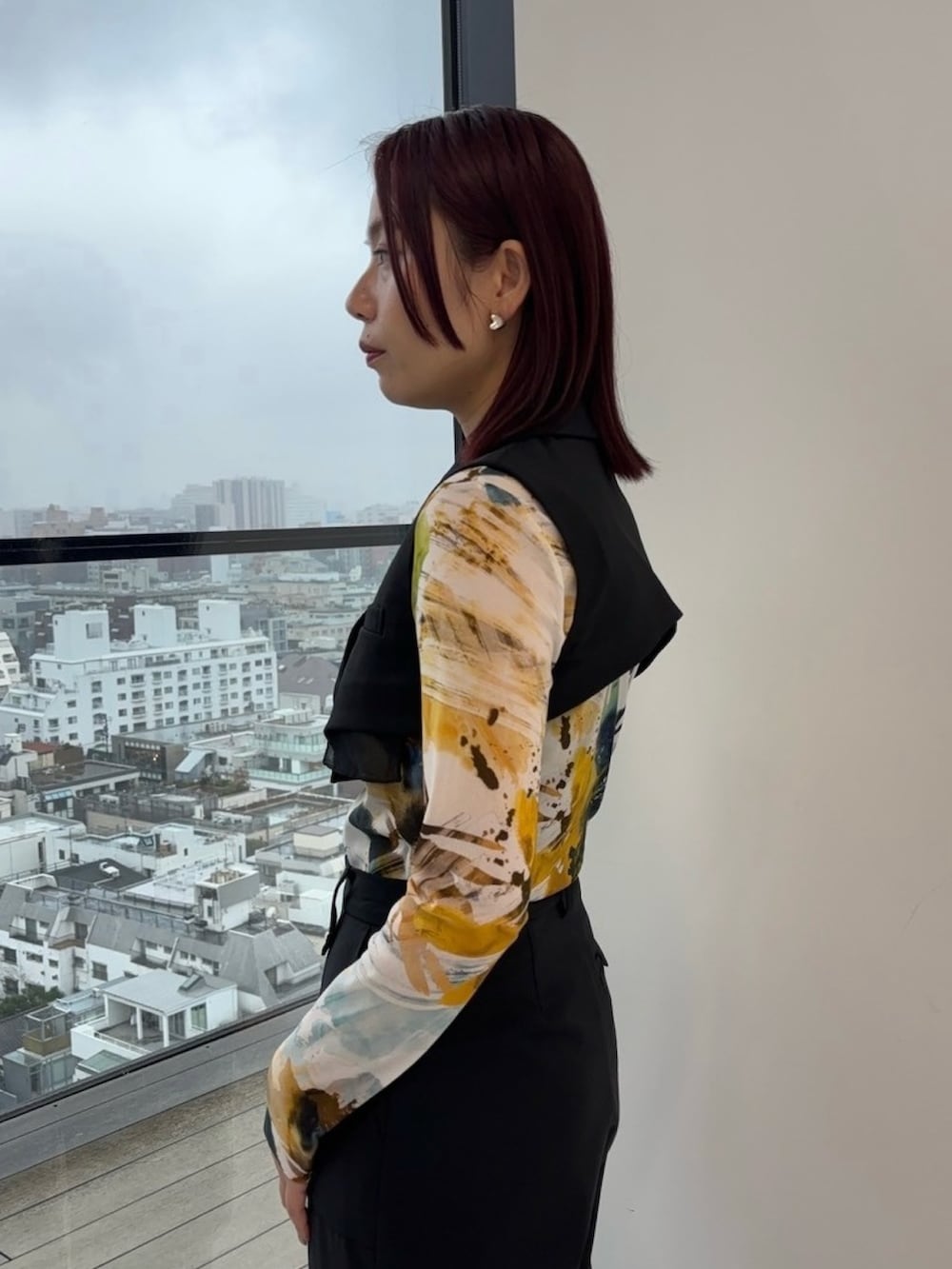 ブラック系のジャンパースカート、ブラック系のカーゴパンツ、イエロー系のTシャツ/カットソーを着用したレディースの冬コーディネートの6枚目の写真