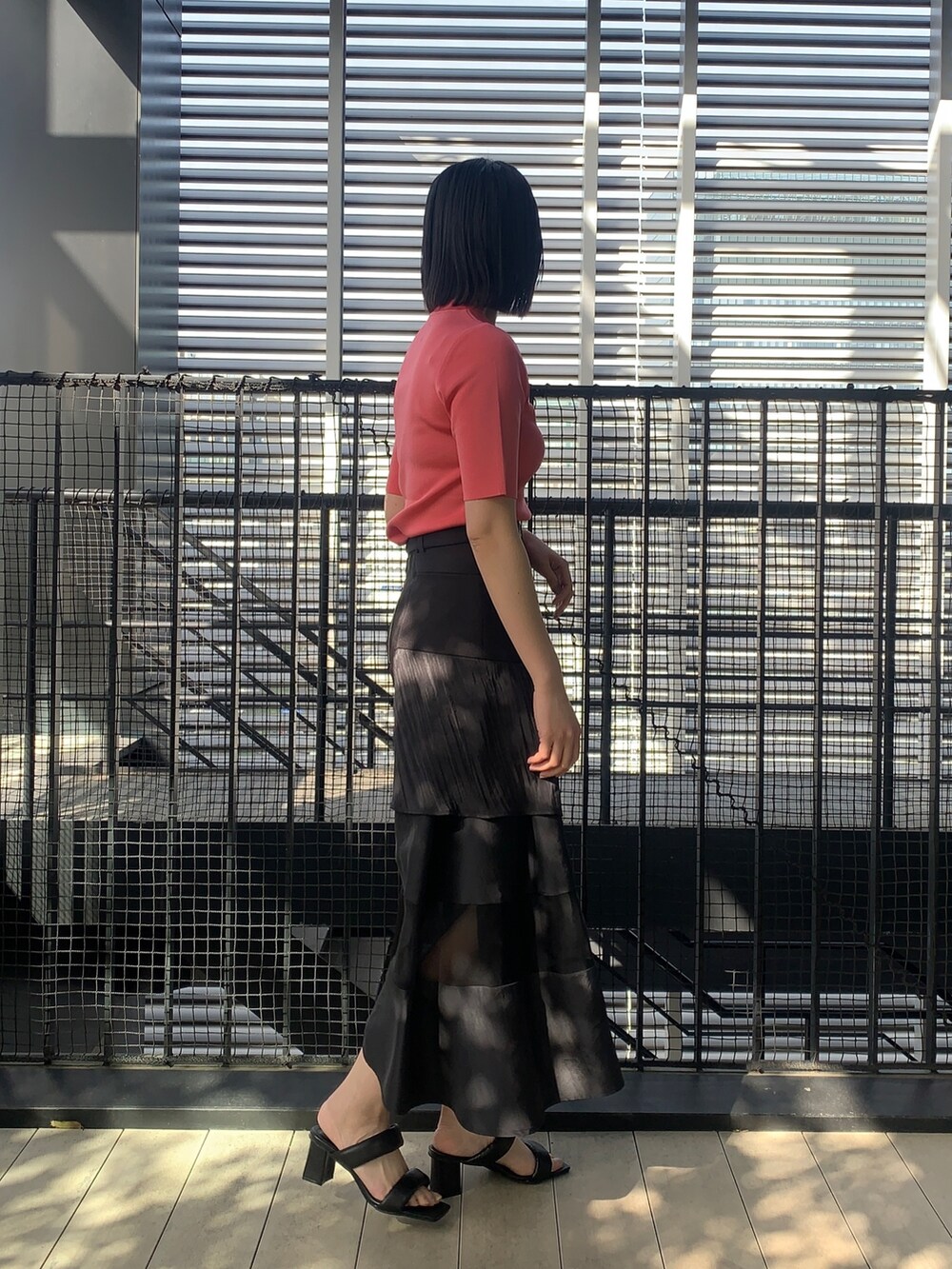 ピンク系のニット/セーター、ブラック系のスカート、ブラック系のその他シューズを着用したレディースの春コーディネートの2枚目の写真