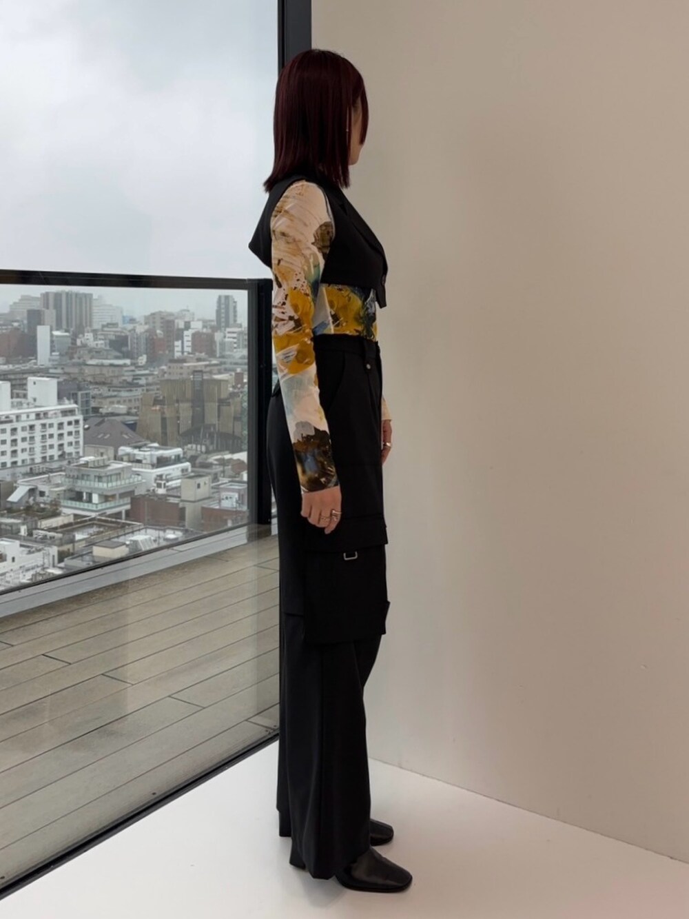 ブラック系のジャンパースカート、ブラック系のカーゴパンツ、イエロー系のTシャツ/カットソーを着用したレディースの冬コーディネートの4枚目の写真