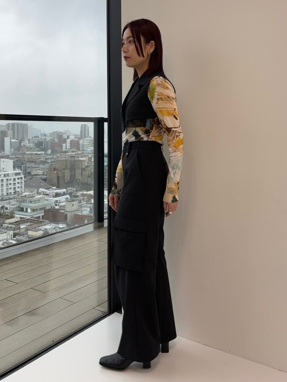 ブラック系のジャンパースカート、ブラック系のカーゴパンツ、イエロー系のTシャツ/カットソーを着用したレディースの冬コーディネートの2枚目の写真