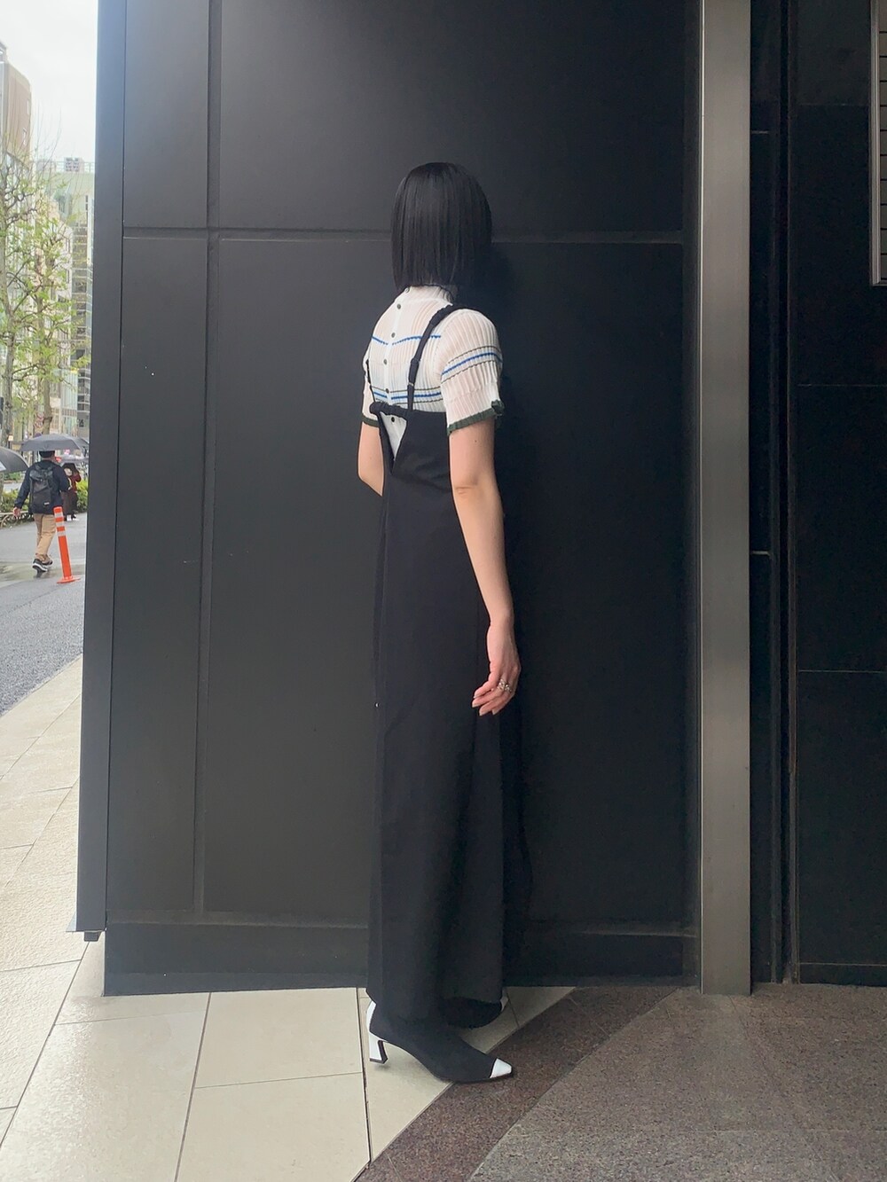 ブラック系のワンピース/ドレス、ベージュ系のニット/セーター、ブラック系のブーツを着用したレディースの春コーディネートの3枚目の写真