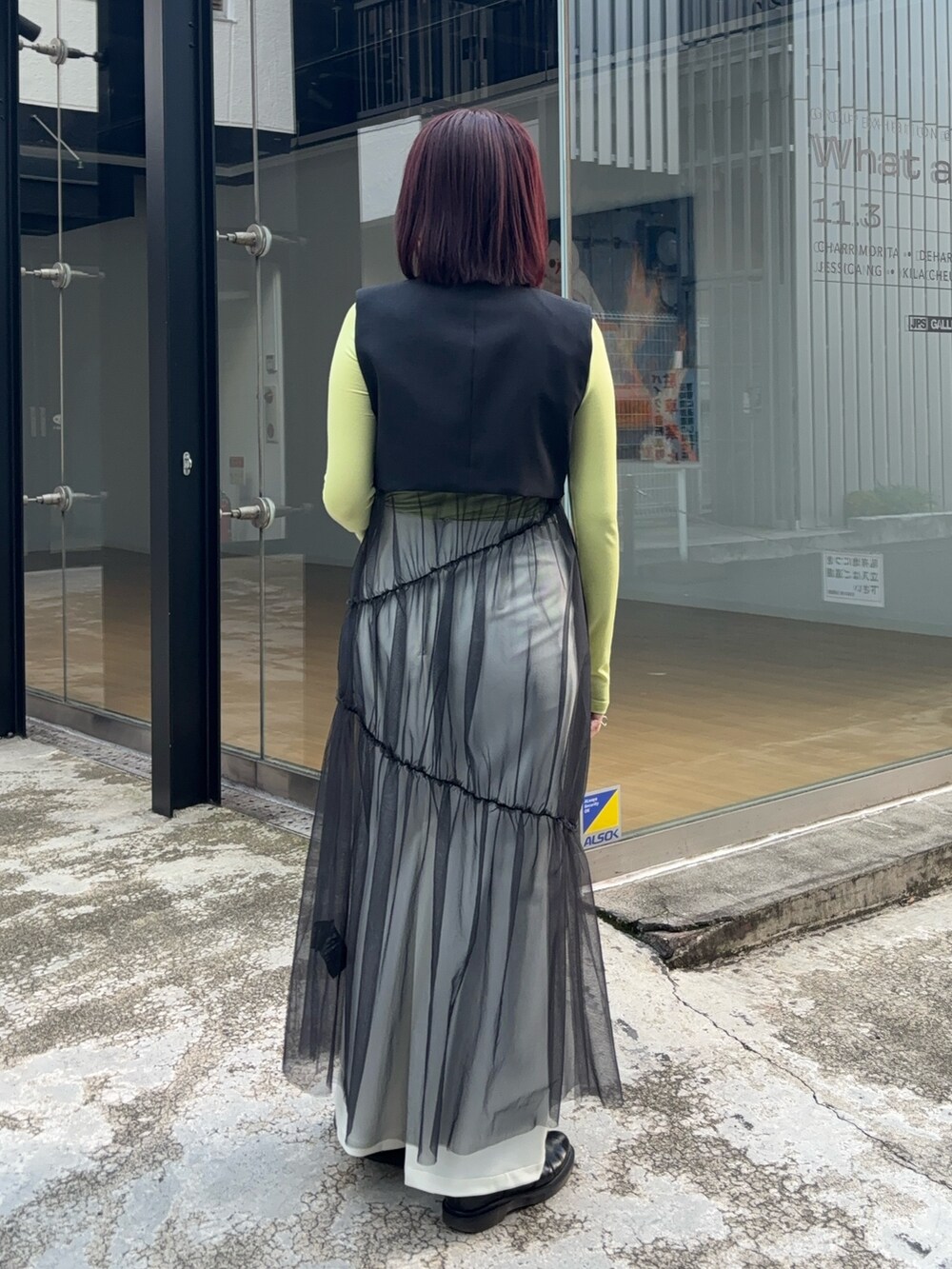 ブラック系のワンピース、グリーン系のTシャツ/カットソー、ホワイト系のスカートを着用したレディースの秋コーディネートの3枚目の写真