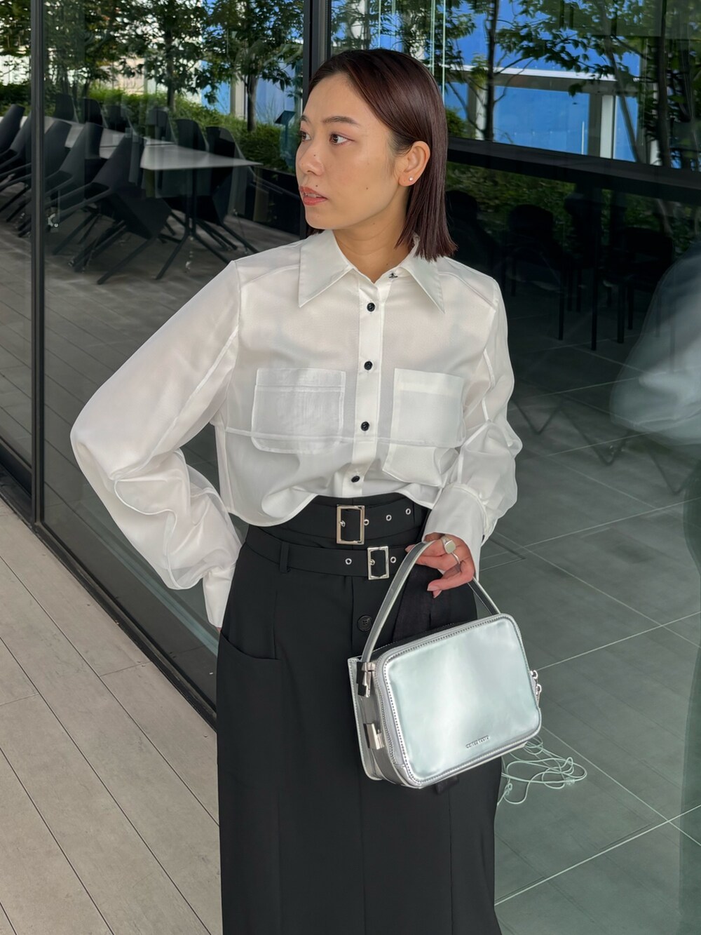 ブラック系のスカート、ブラック系のブーツを着用したレディースの秋コーディネートの4枚目の写真