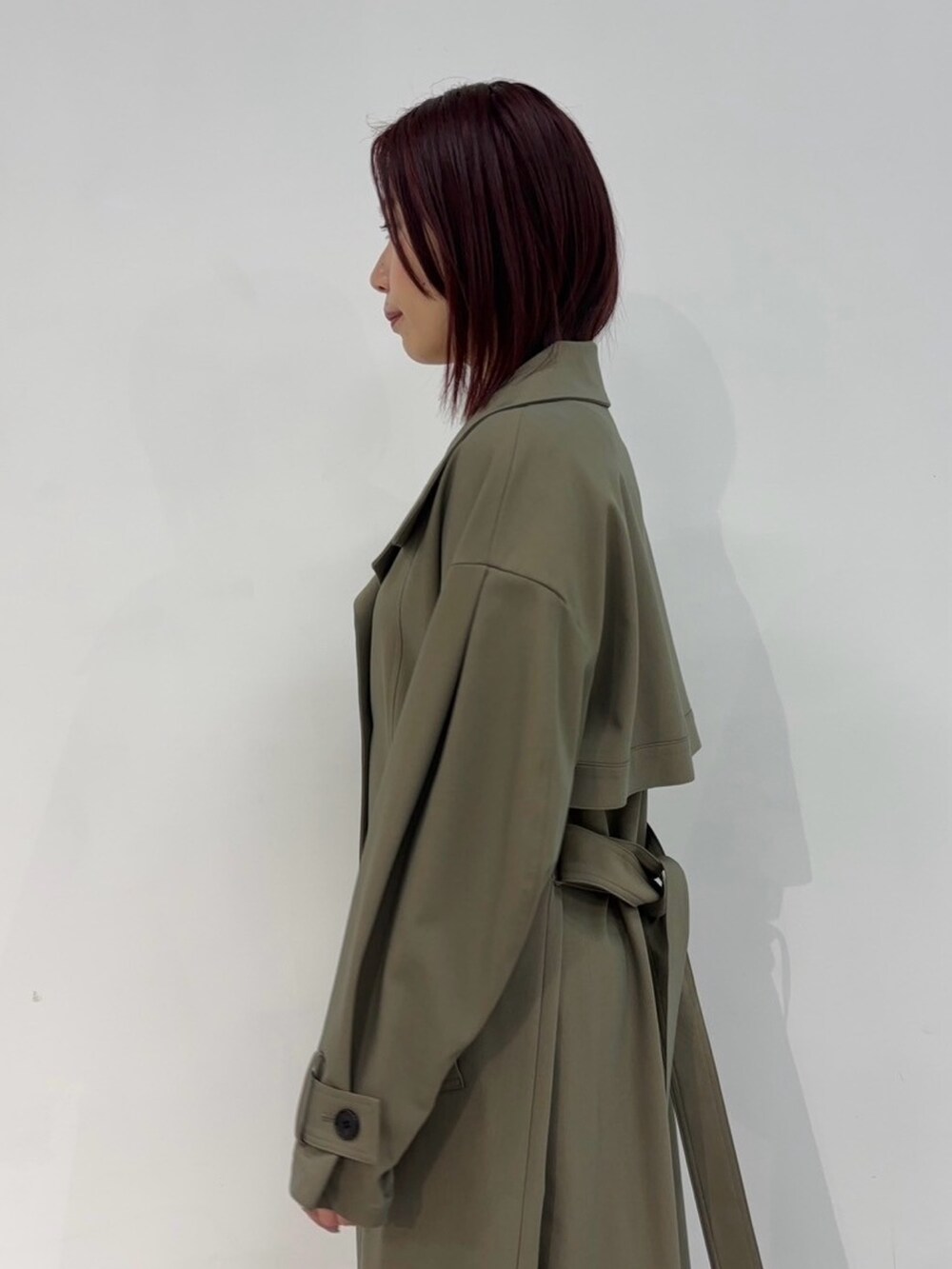 ブラウン系のトレンチコートを着用したレディースの冬コーディネートの6枚目の写真