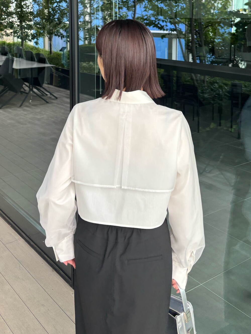 ブラック系のスカート、ブラック系のブーツを着用したレディースの秋コーディネートの3枚目の写真