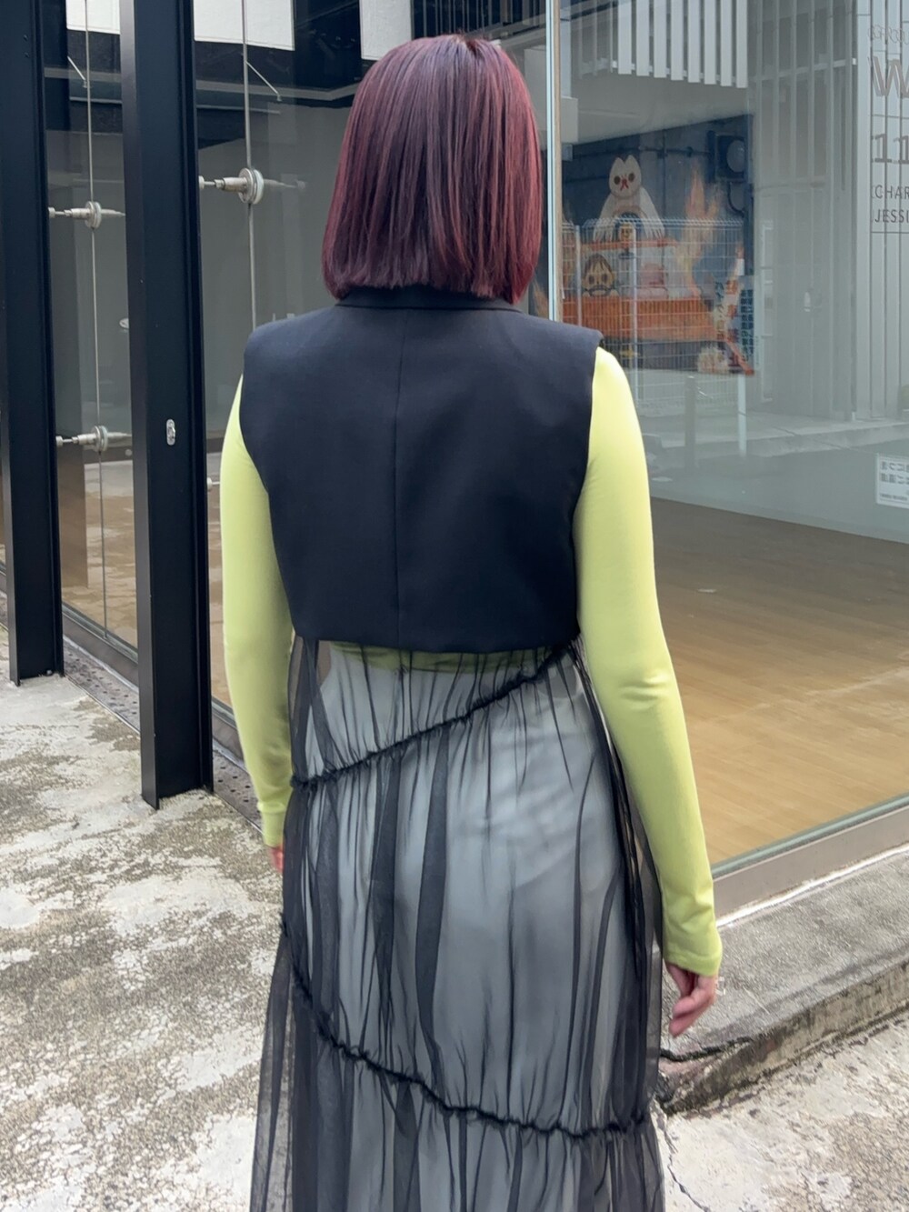 ブラック系のワンピース、グリーン系のTシャツ/カットソー、ホワイト系のスカートを着用したレディースの秋コーディネートの6枚目の写真