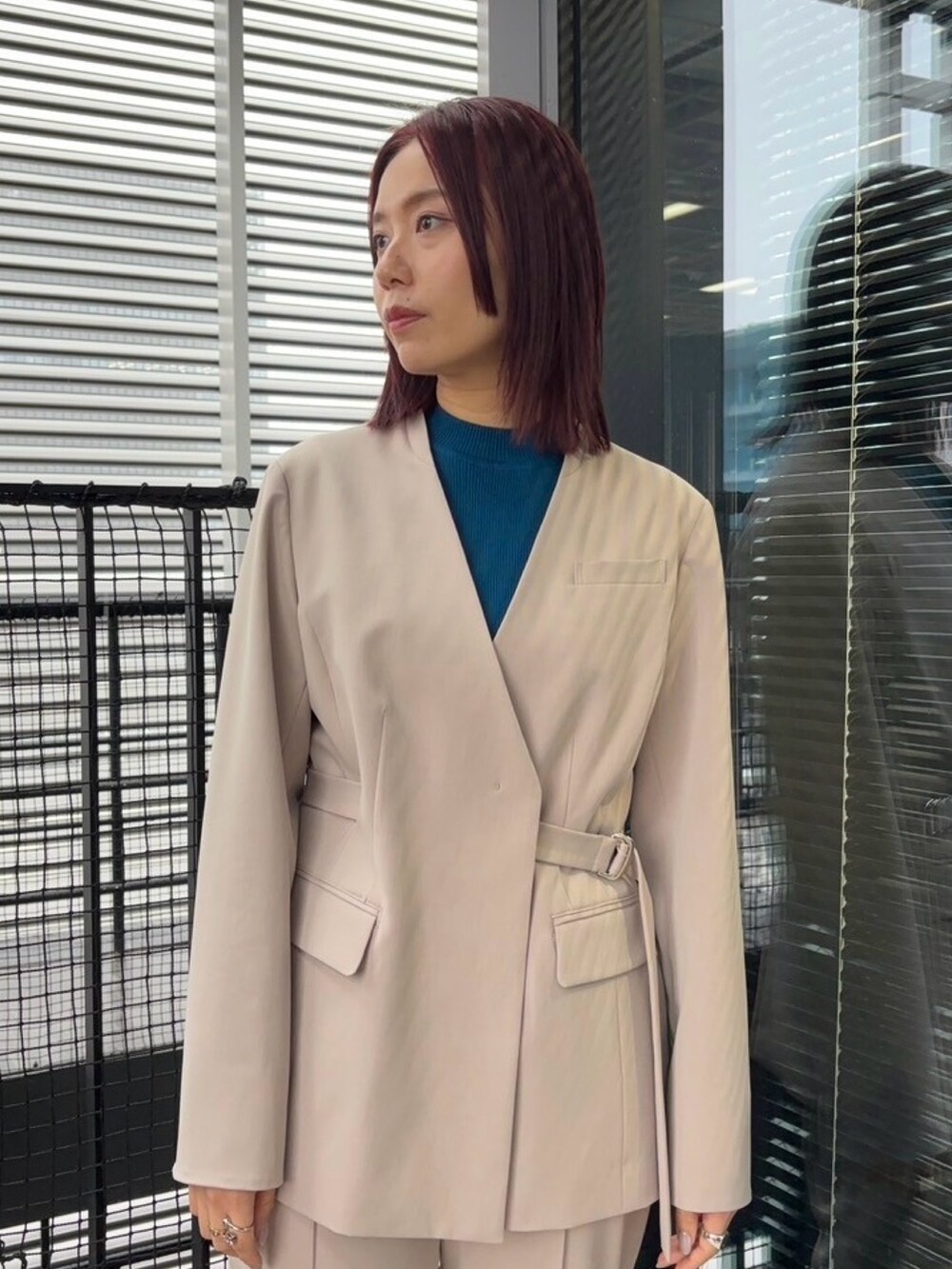 ブルー系のニット/セーター、ベージュ系のスラックス、ベージュ系のセットアップを着用したレディースの冬コーディネートの7枚目の写真