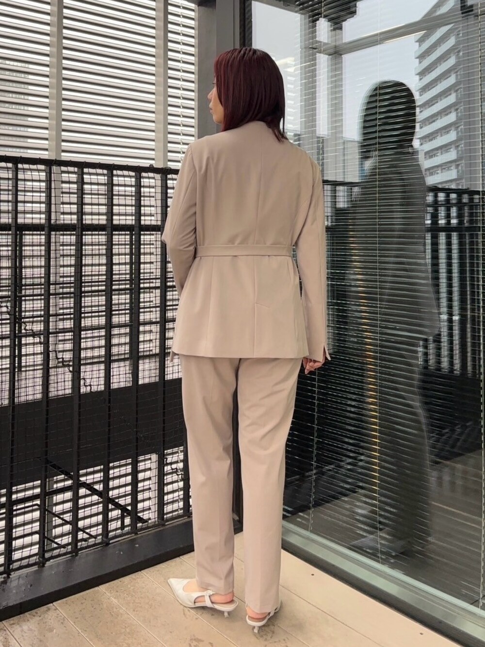 ブルー系のニット/セーター、ベージュ系のスラックス、ベージュ系のセットアップを着用したレディースの冬コーディネートの3枚目の写真