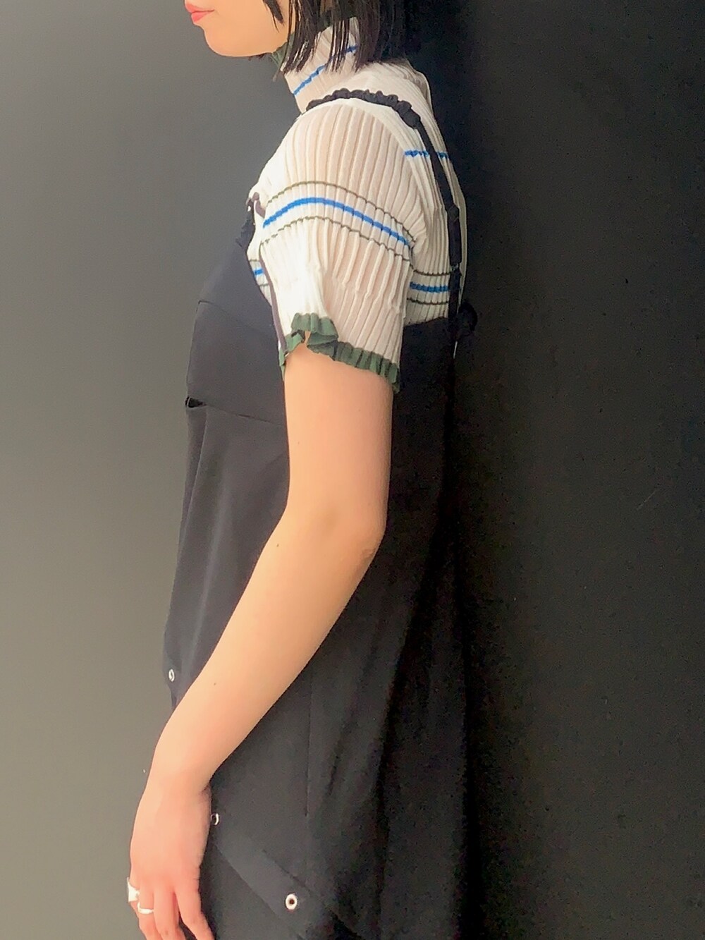 ブラック系のワンピース/ドレス、ベージュ系のニット/セーター、ブラック系のブーツを着用したレディースの春コーディネートの5枚目の写真